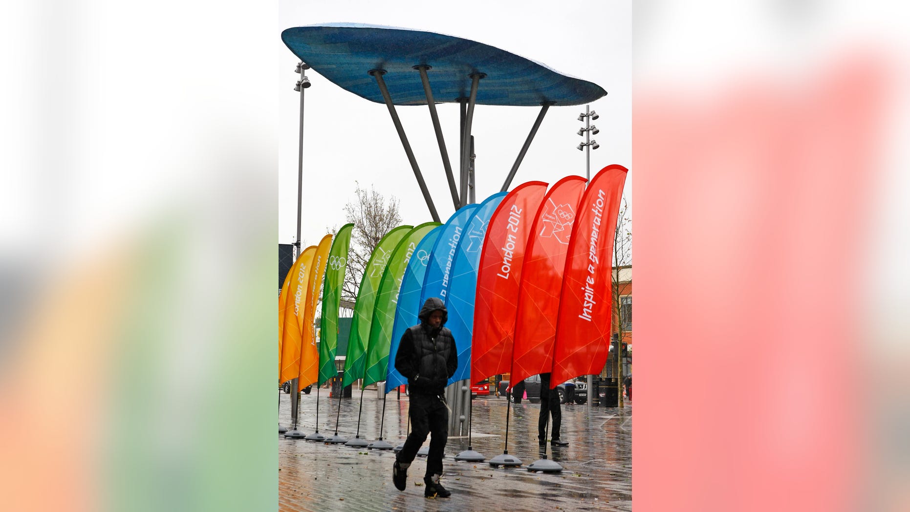 June 8, 2012: A man walks along the first London high street to be adorned with official banners, bunting and flags of the 2012 Olympic and Paralympic Games, Stratford, London.