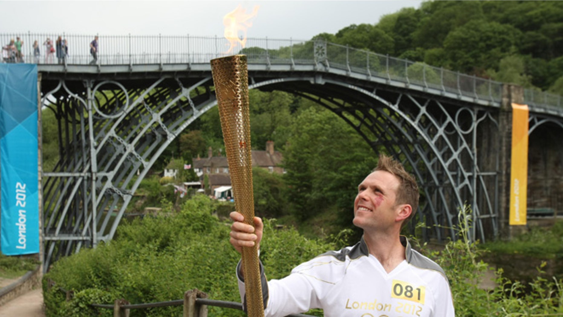 Lyndon Flavell holds the Olympic Flame next to the Iron Bridge at Ironbridge Gorge between Much Wenlock and Telford in central England.