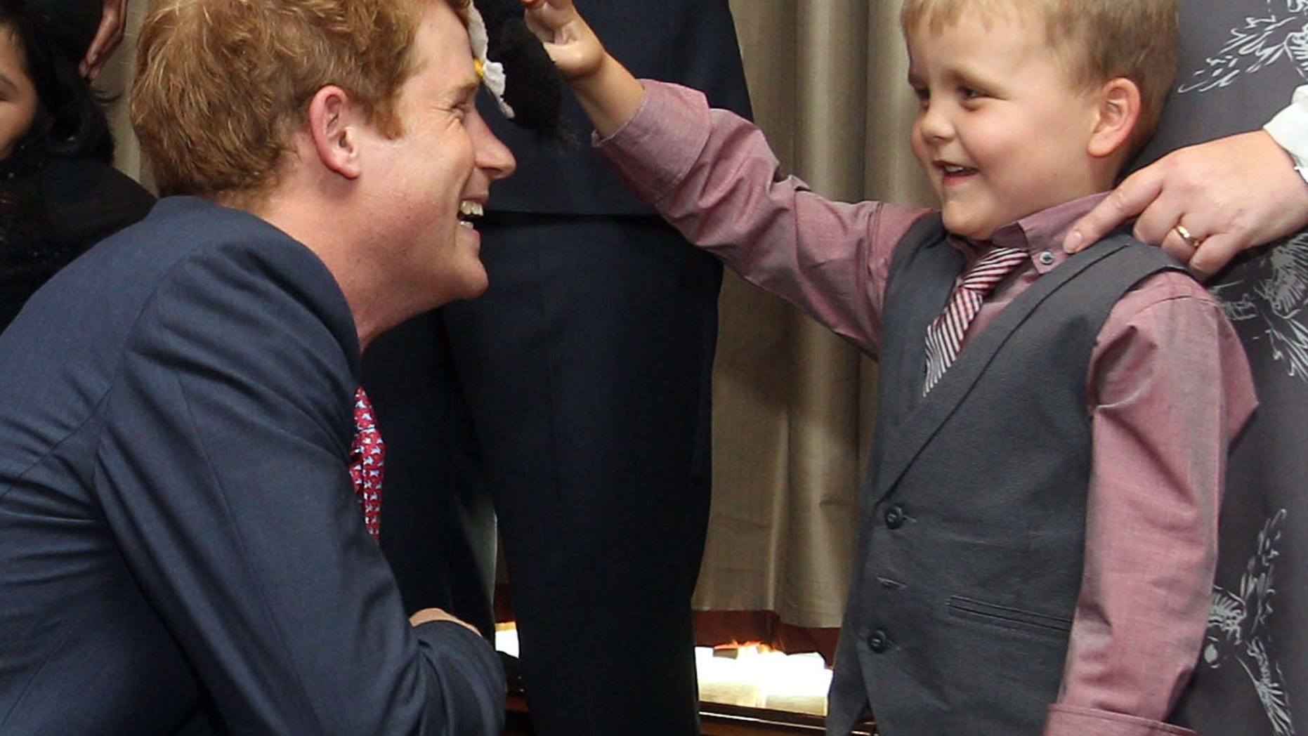 Sept. 3, 2012: Britain's Prince Harry talks to Alex Logan, right, who puts a toy penguin against his head, as he attends the WellChild awards ceremony InterContinental Park Lane Hotel, London.