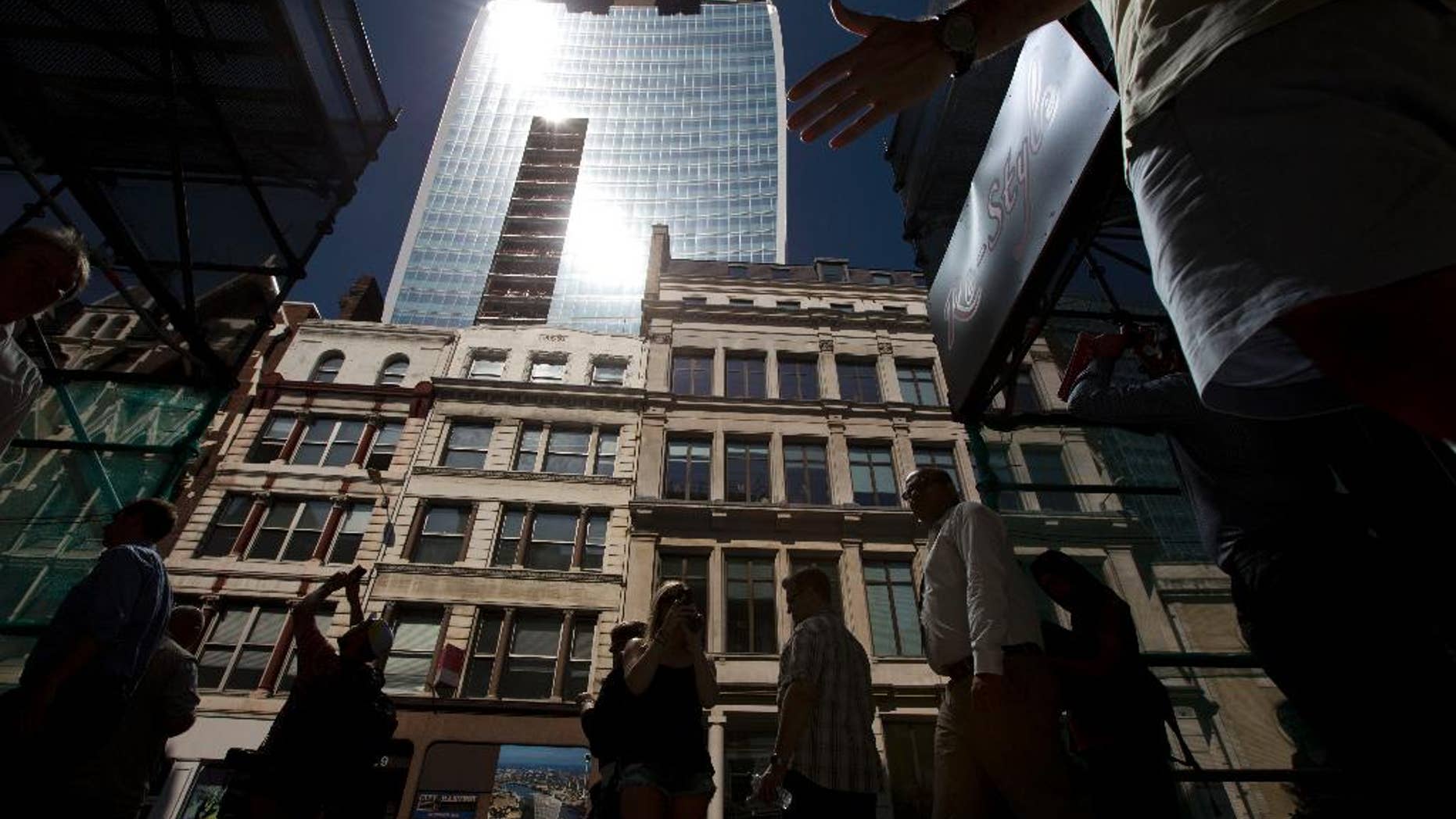 FILE - In this Thursday, Sept. 5, 2013 file photo, intense sunlight reflects down towards street level off the 37-storey skyscraper at 20 Fenchurch Street in the City of London. A London skyscraper which drew ire for having a glare so strong it melted nearby cars and shops will get a permanent fix. Developers say the tower, known as the Walkie-Talkie for its curved shape, is to have a sunshade attached to its south-facing facade to stop it from reflecting sun rays and beaming them in concentrated form to a nearby street. (AP Photo/Matt Dunham, File)