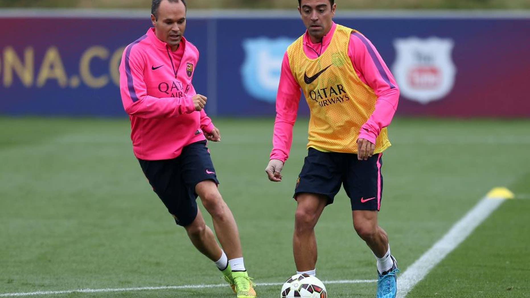 Barcelona's Xavi, right, and Andres Iniesta, run, during a pre-season training session, at St George's Park, Burton-Upon-Trent, England, Friday Aug. 1, 2014. (AP Photo/PA, Simon Cooper) UNITED KINGDOM OUT
