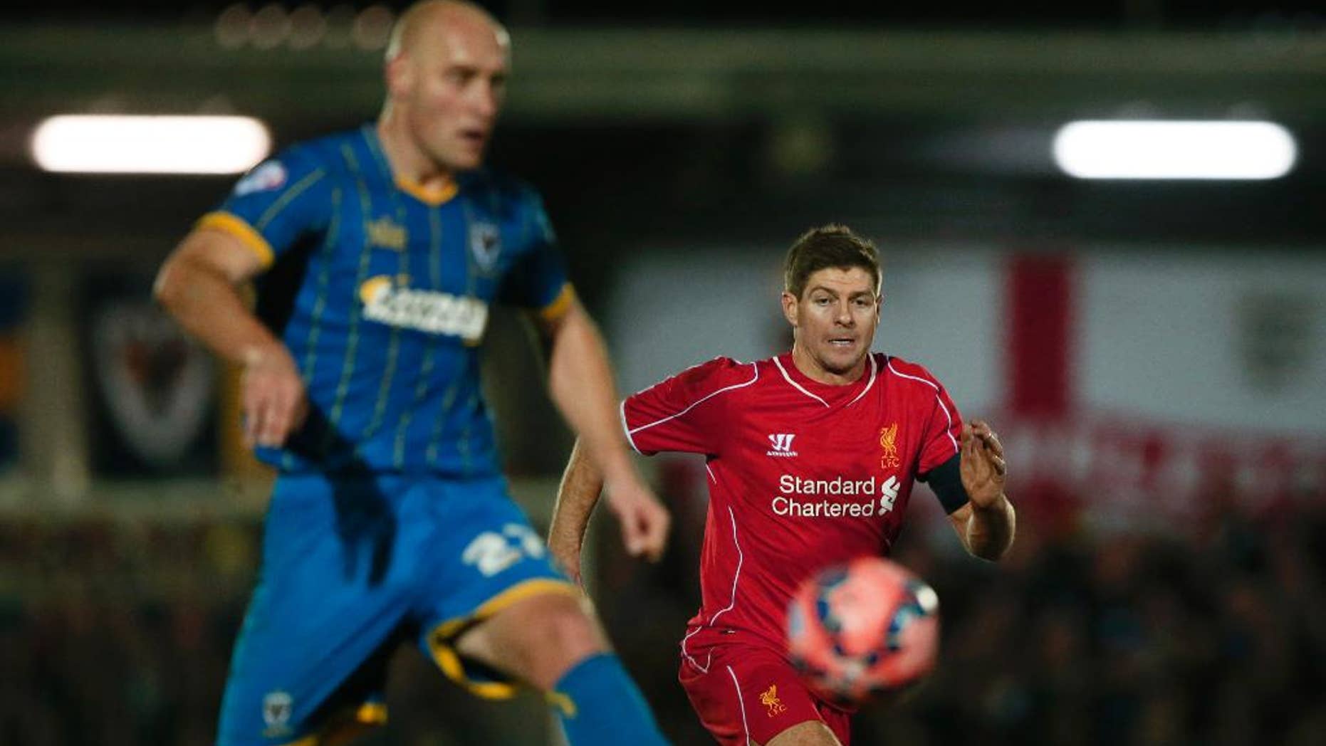 Liverpool's Steven Gerrard, right watches as =AFC Wimbledon's Adam Barratt passes back to his goalkeeper during their English FA Cup third round soccer match between AFC Wimbledon and Liverpool in Kingston, London, Monday, Jan. 5, 2015 . (AP Photo/Alastair Grant)