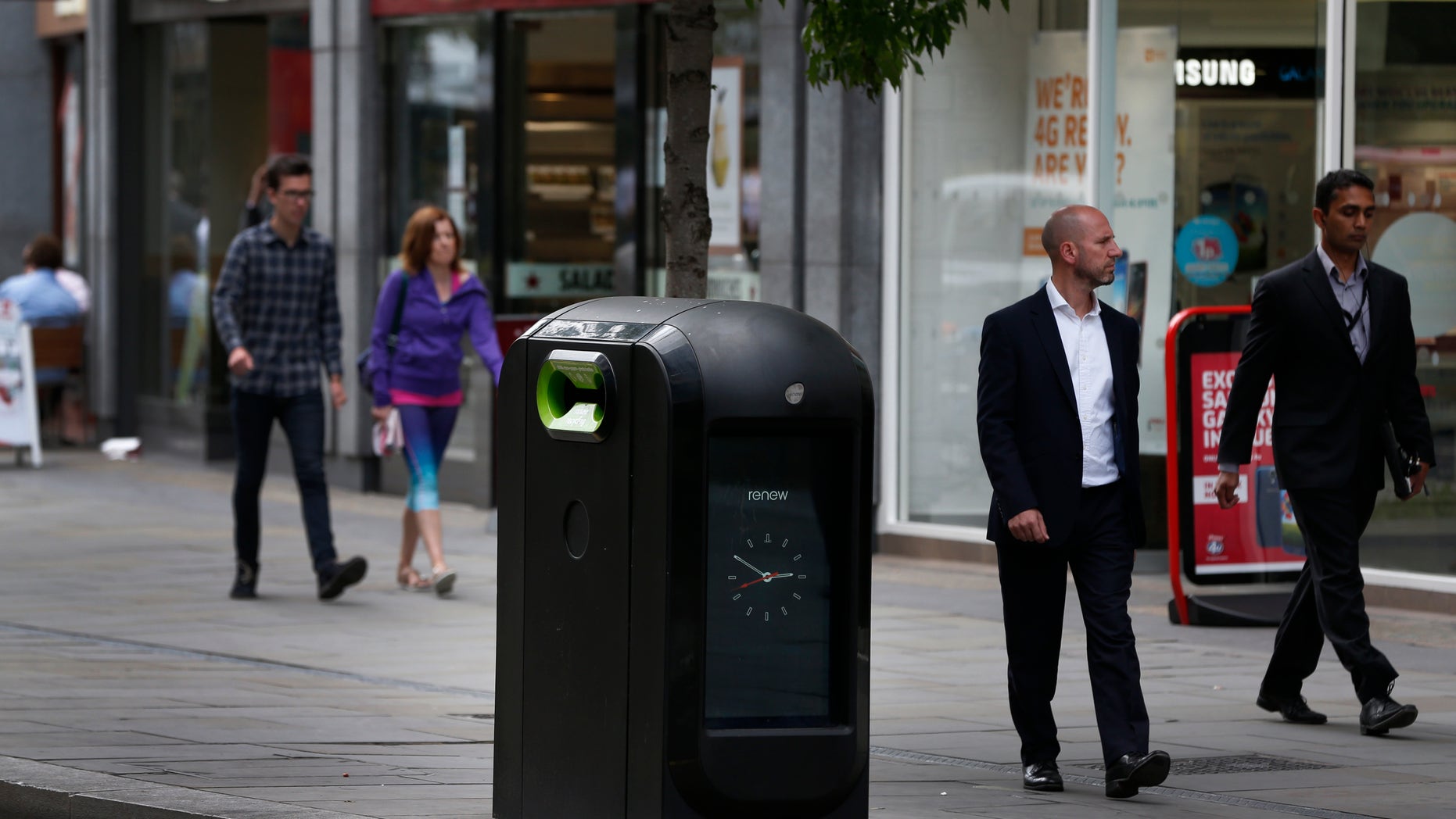 Aug. 12, 2012 - People walk past a trash bin in central London. Officials say an advertising firm must immediately stop using its network of high-tech trash cans, like this one, to track people walking through London's financial district.