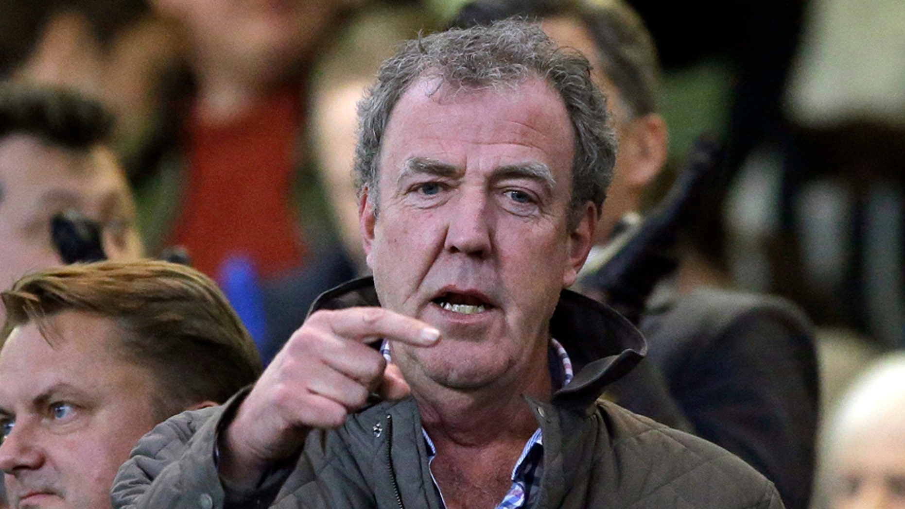 FILE - In this Wednesday, March 11, 2015 file photo TV host Jeremy Clarkson gestures as he takes his place in the stands before the Champions League round of 16 second leg soccer match between Chelsea and Paris Saint Germain at Stamford Bridge stadium in London. Clarkson, the former host of hit BBC auto show "Top Gear," has apologized and paid an undisclosed sum to a producer he punched in an off-set altercation it was reported on Wednesday, Feb. 24, 2016. Clarkson was fired in March 2015 after hitting Oisin Tymon during a dispute at the end of a day's filming. (AP Photo/Matt Dunham, File)