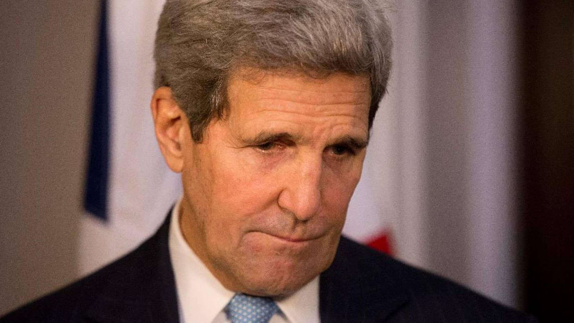 US Secretary of State John Kerry looks down as Britain's Foreign Secretary Philip Hammond speaks to the media about the attack that took place this morning on worshippers in a Jerusalem synagogue before their breakfast meeting at 1 Carlton Gardens in London, Tuesday, Nov. 18, 2014. (AP Photo/Matt Dunham, Pool)