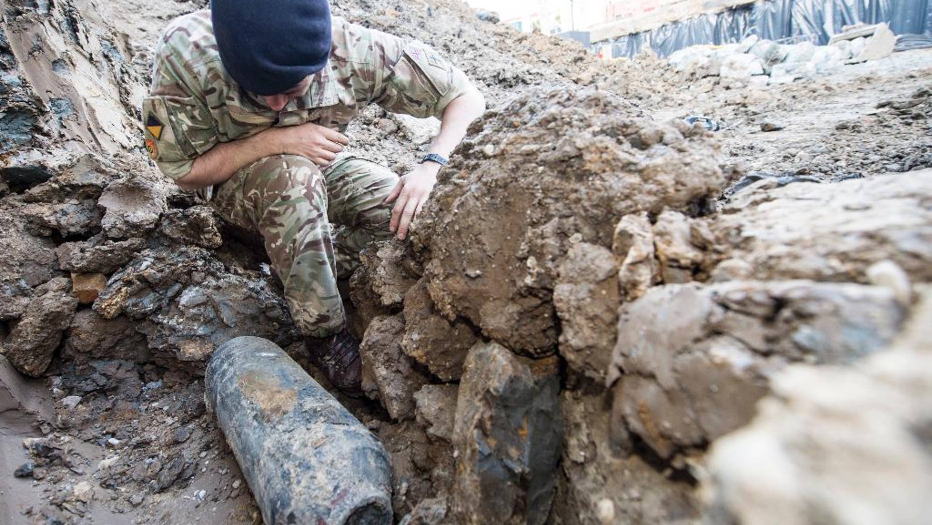 An army bomb disposal expert inspects an unexploded World War II bomb found in Wembley, north London, Thursday May 21, 2015. The 50-kilogram (110-pound) bomb was discovered by workers at a construction site near Wembley stadium. It is believed to have been dropped over London during German bombing raids in the early 1940s. (Sergeant Rupert Frere of the Royal Logistic Corrps/MoD Crown Copyright via AP) NO SALES