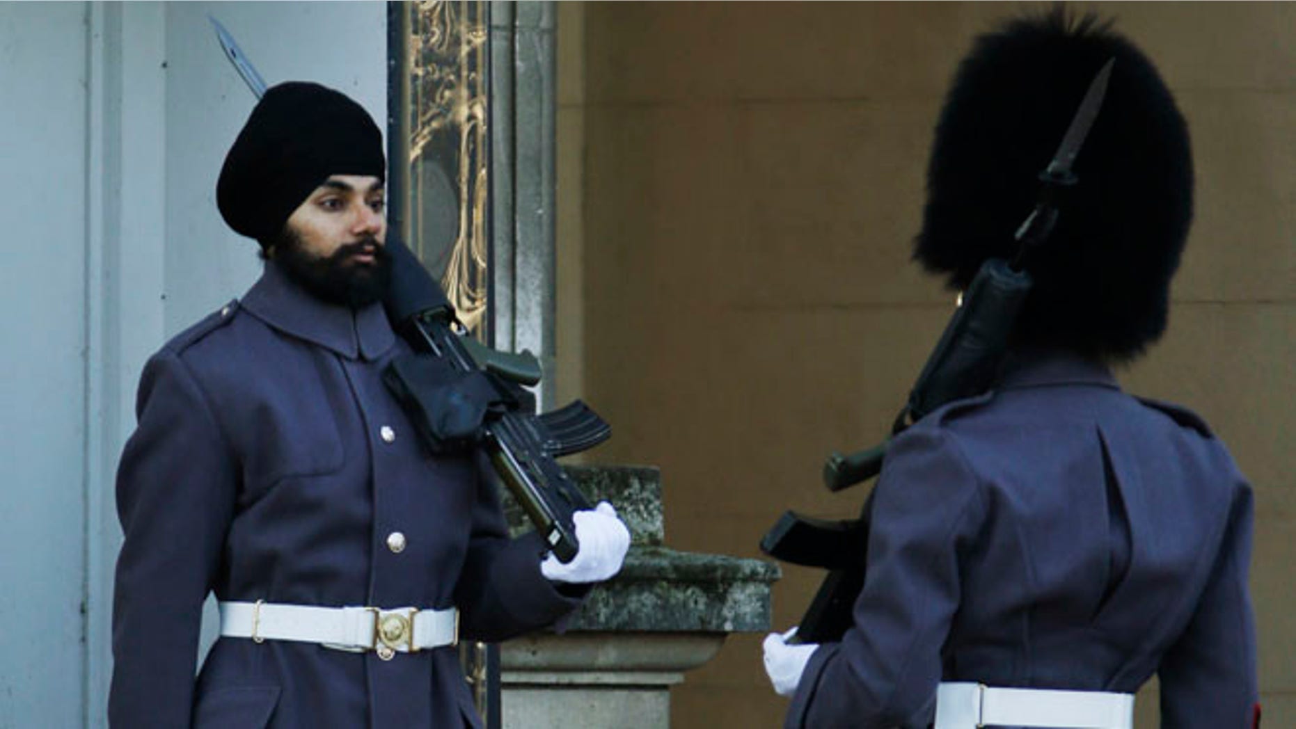 Dec. 11: An officer, right, checks Jatinderpal Singh Bhullar, 25, a Sikh soldier with the Scots Guards, performs guarding duties outside Buckingham Palace in London.