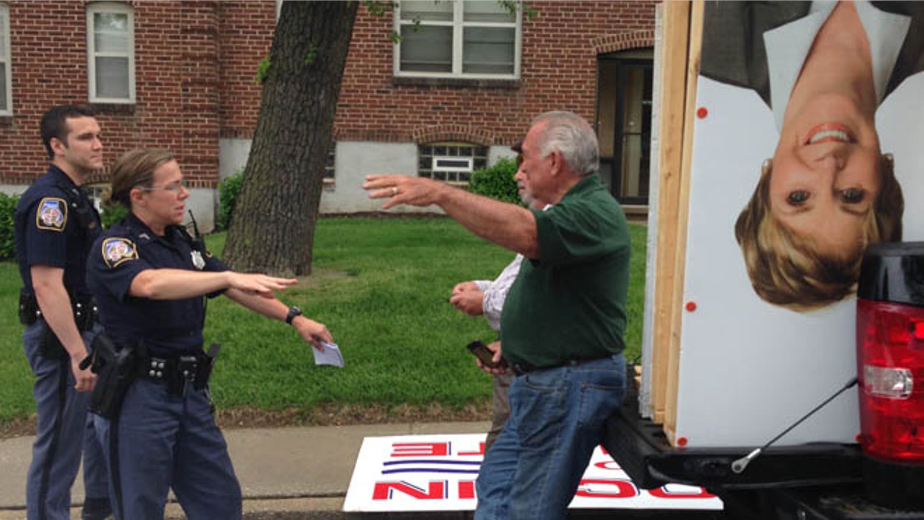May 10, 2014: J. Ronald DeJuliis, a commissioner for Maryland Democratic Gov. Martin O'Malley talks to police about campaign signs, Balto., Md.