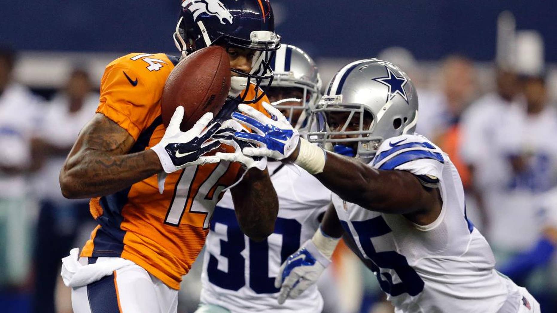 FILE - In this Aug. 28, 2014, file photo, Denver Broncos wide receiver Cody Latimer (14) grabs a pass under pressure from Dallas Cowboys cornerback Terrance Mitchell (30) and cornerback Tyler Patmon, right, in the second half of a NFL preseason football game in Arlington, Texas. Latimer says he's ready to make an impact in Denver's complex offense, and he might just get that chance Sunday against Miami with two of Peyton Manning's top targets sidelined. (AP Photo/LM Otero, File)
