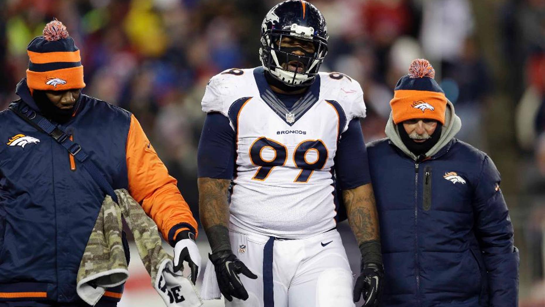 FILE - In this Nov. 24, 2013 file photo, Denver Broncos defensive tackle Kevin Vickerson (99) is helped off the field in the first quarter of an NFL football game against the New England Patriots, in Foxborough, Mass. Vickerson thought he'd be back on the football field by now. Instead, he spends his days still rehabbing his right hip that was dislocated seven months ago in New England and working on his strength and conditioning so that he hold can up 700 pounds of double teams like he used to when he anchored Denver's defense. (AP Photo/Steven Senne, File)