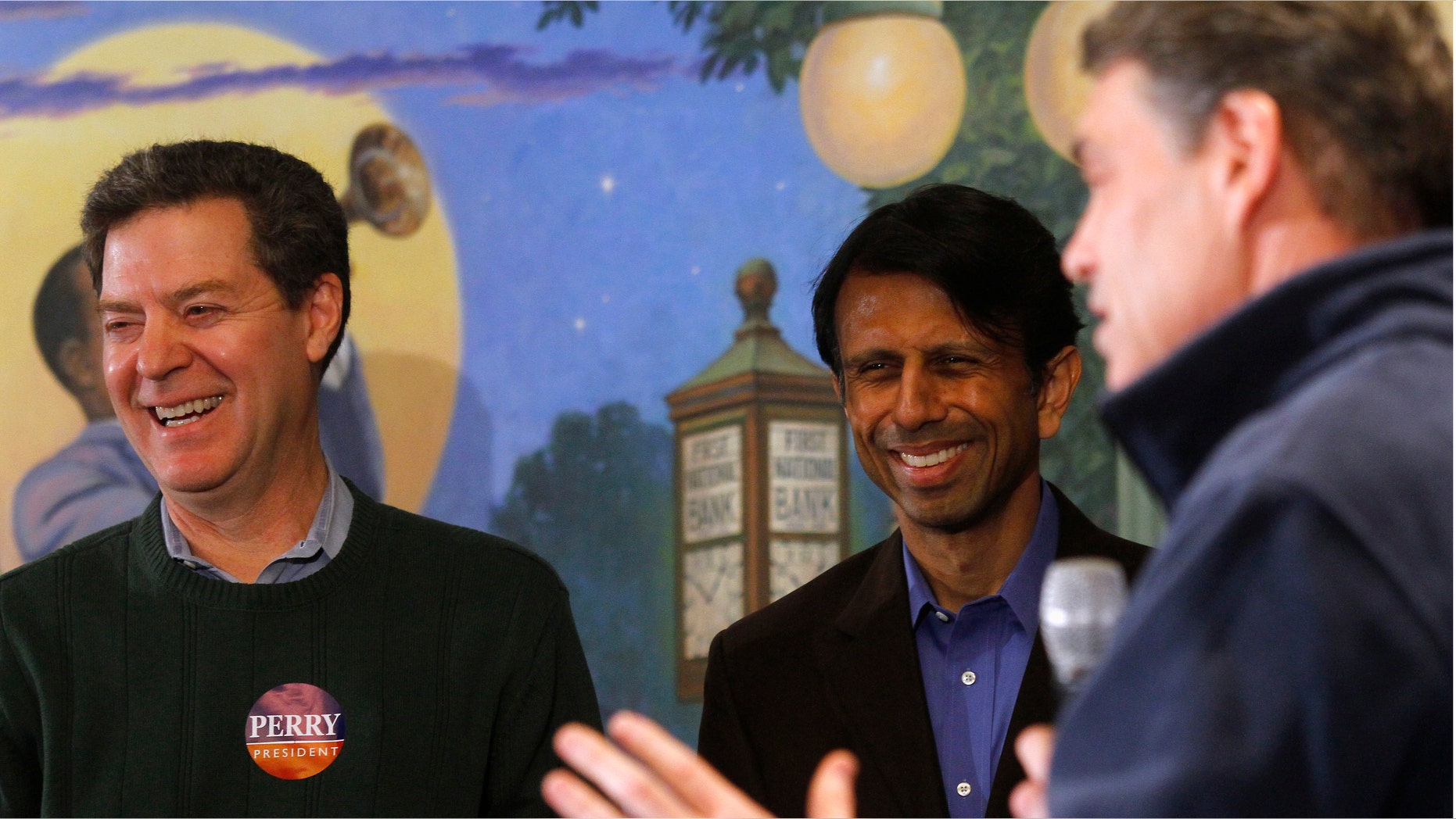 FILE: January 2, 2012: Kansas Gov. Sam Brownback (L), Louisiana Governor Bobby Jindal (C) and then-GOP presidential candidate and Texas Gov. Rick Perry in Perry, Iowa.