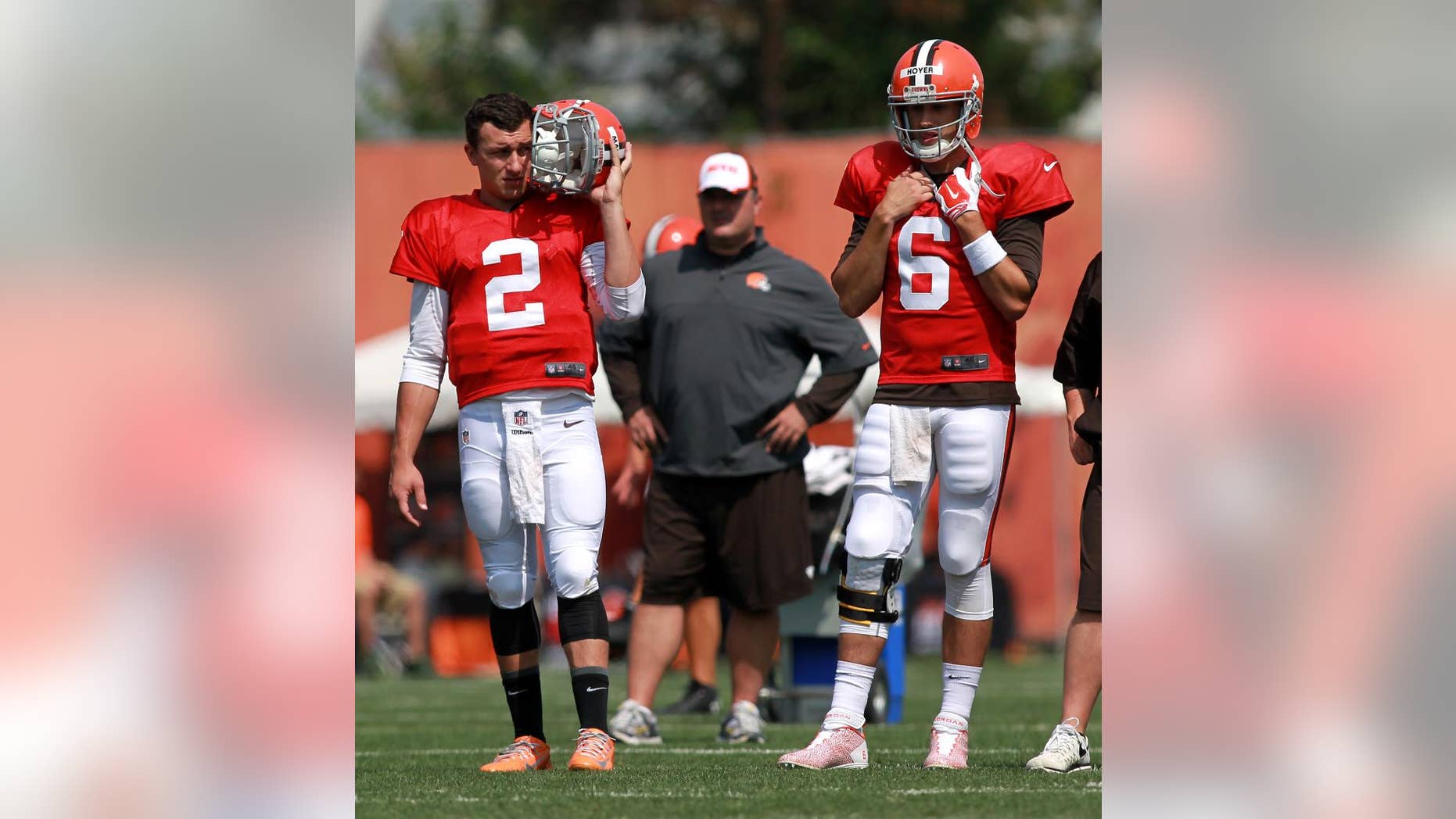 Cleveland Browns quarterbacks Johnny Manziel (2) and Brian Hoyer watch teammates at the NFL football team's training camp in Berea, Ohio, Thursday, July 31, 2014. (AP Photo/Aaron Josefczyk)