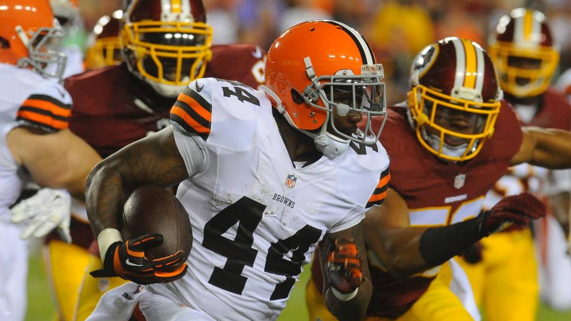 FILE - In this Aug. 18, 2014, file photo, Cleveland Browns running back Ben Tate (44) runs from Washington Redskins defensive end Jarvis Jenkins (99) and linebacker Keenan Robinson (52) during the first half of an NFL preseason football game in Landover, Md. Tate has returned to practice after missing Cleveland's past two games with a sprained right knee. Wearing a brace, Tate was on the practice field Tuesday, Sept. 30, 2014, for the first time since Sept. 5 as the Browns returned from their bye week. (AP Photo/Richard Lipski, File)