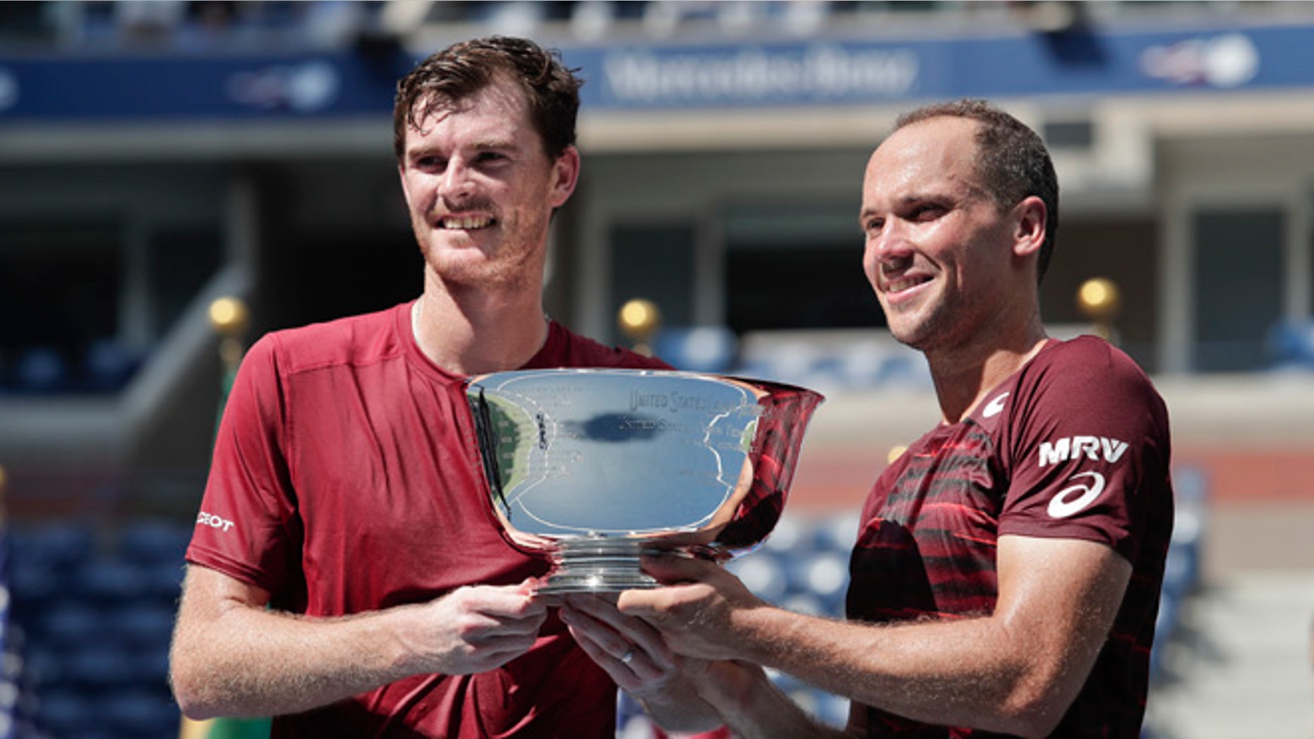 Jamie Murray, of the United Kingdom, left, and Bruno Soares, of Brazil, pose for a photo with the championship trophy after beating Pablo Carreno Busta, of Spain, and Guillermo Garcia-Lopez, of Spain, to win the men's doubles final of the U.S. Open tennis tournament, Saturday, Sept. 10, 2016, in New York. (AP Photo/Julie Jacobson)