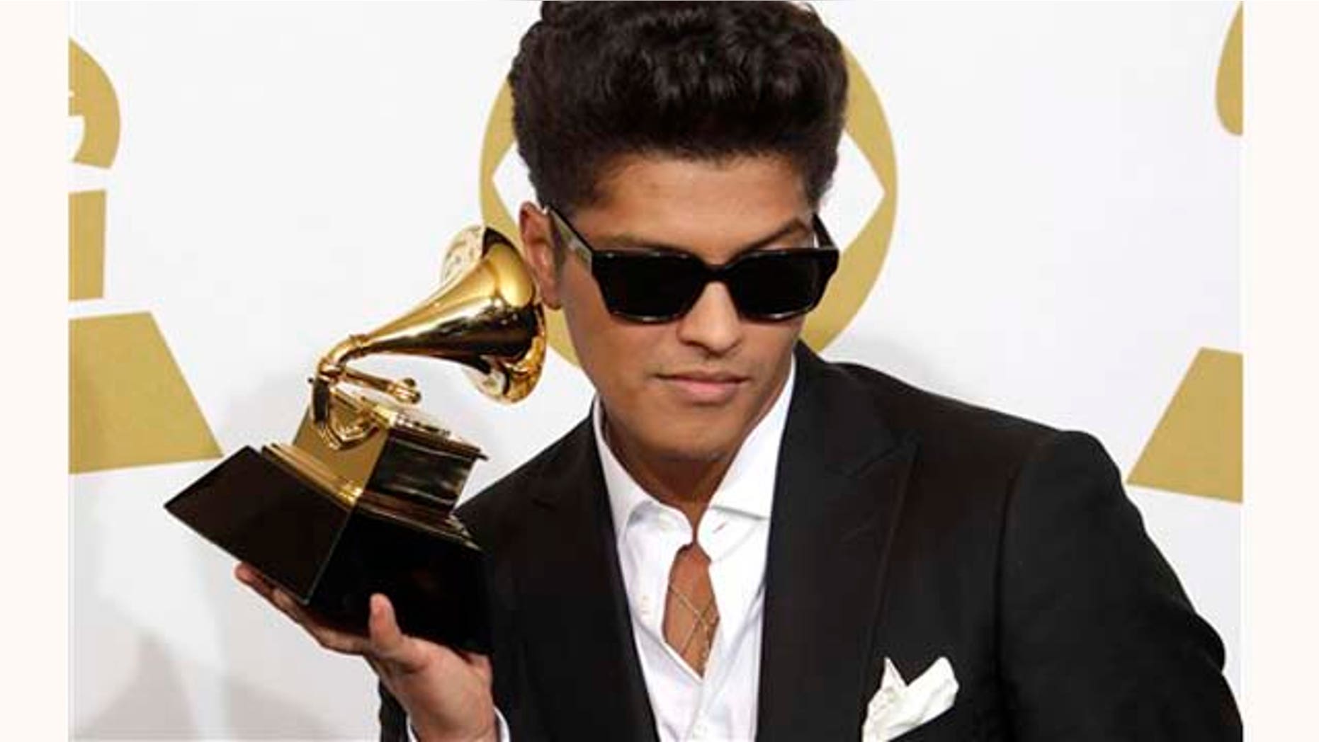 Bruno Mars poses backstage with the award for best male pop vocal performance at the 53rd annual Grammy Awards on Sunday, Feb. 13, 2011, in Los Angeles. (AP Photo/Jae C. Hong)