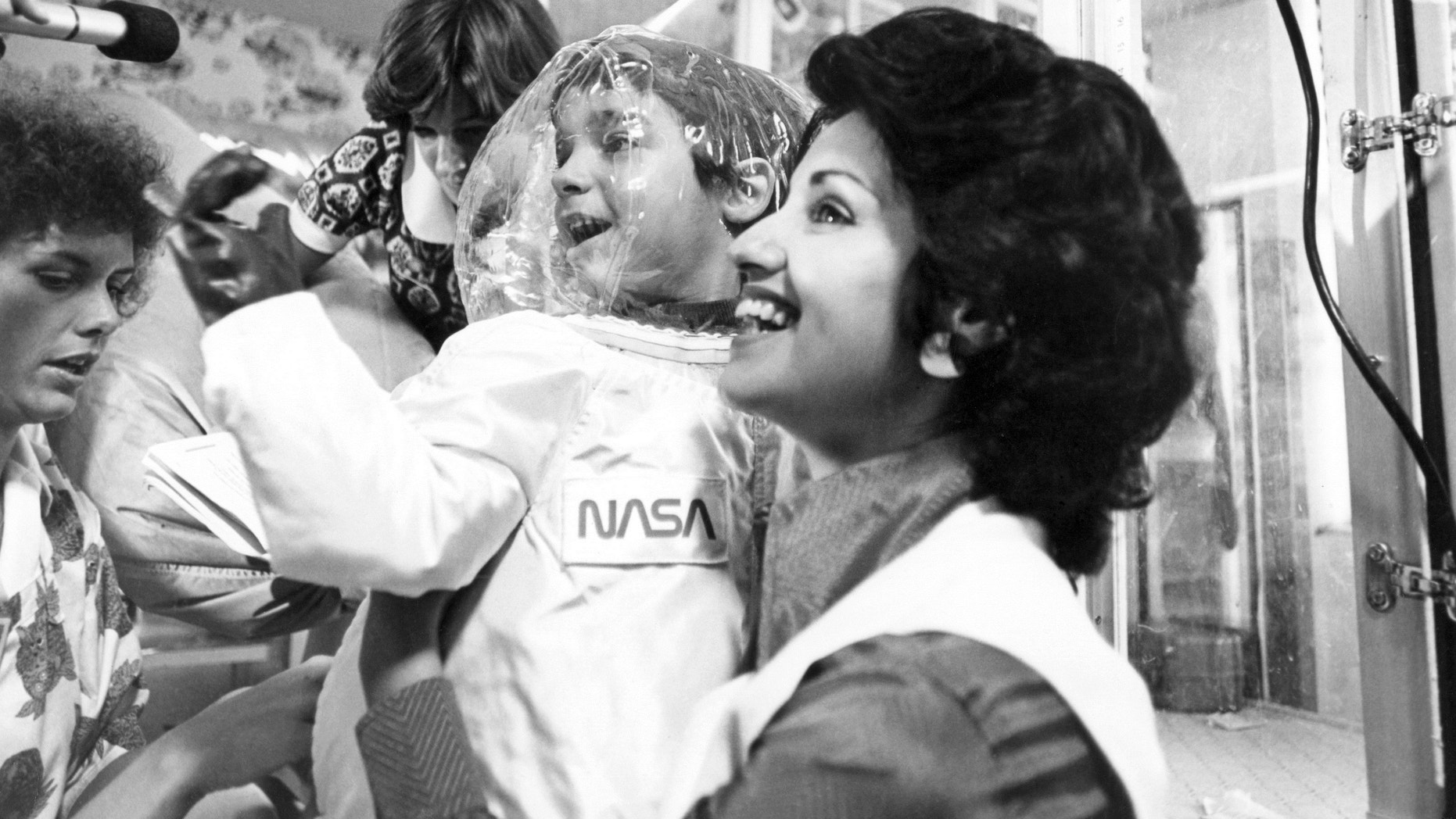 Carol Ann holds her son David while he wears a suit specially designed by NASA, on July 29, 1977.