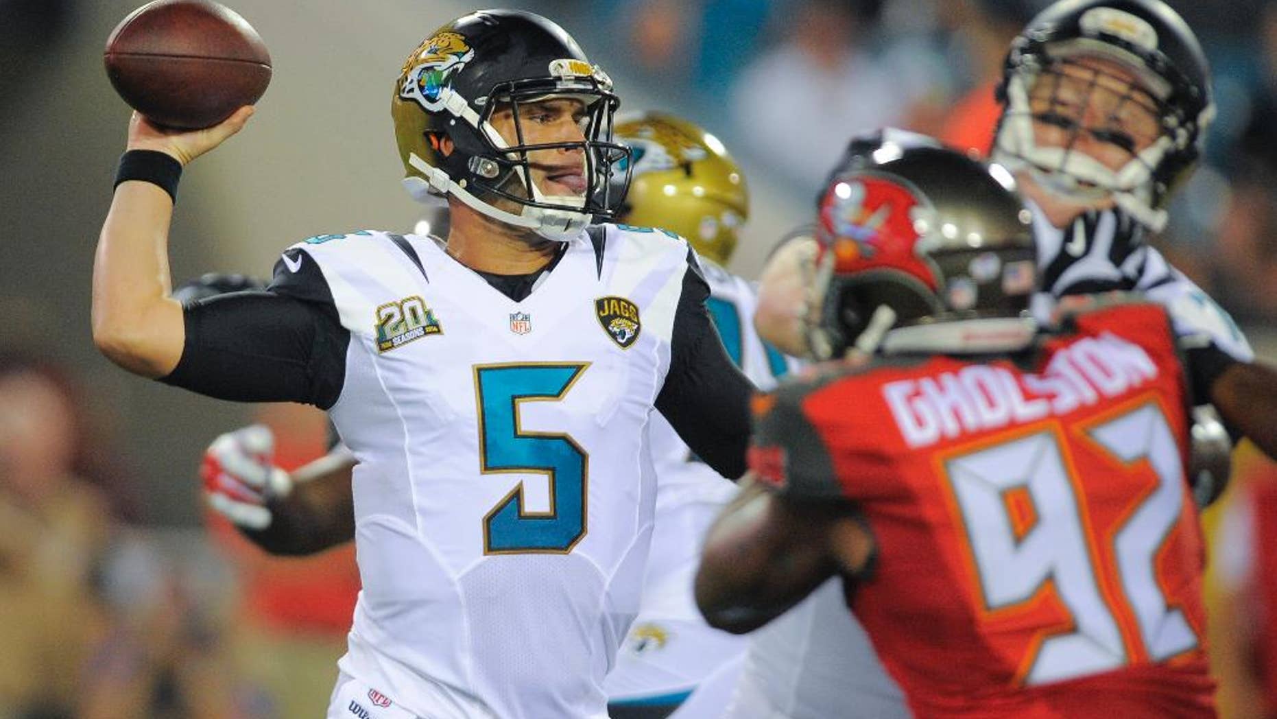 Jacksonville Jaguars quarterback Blake Bortles (5) throws a pass as he is pressured by Tampa Bay Buccaneers defensive end William Gholston (92) during the first half of an NFL preseason football game in Jacksonville, Fla., Friday, Aug. 8, 2014. (AP Photo/Stephen B. Morton)