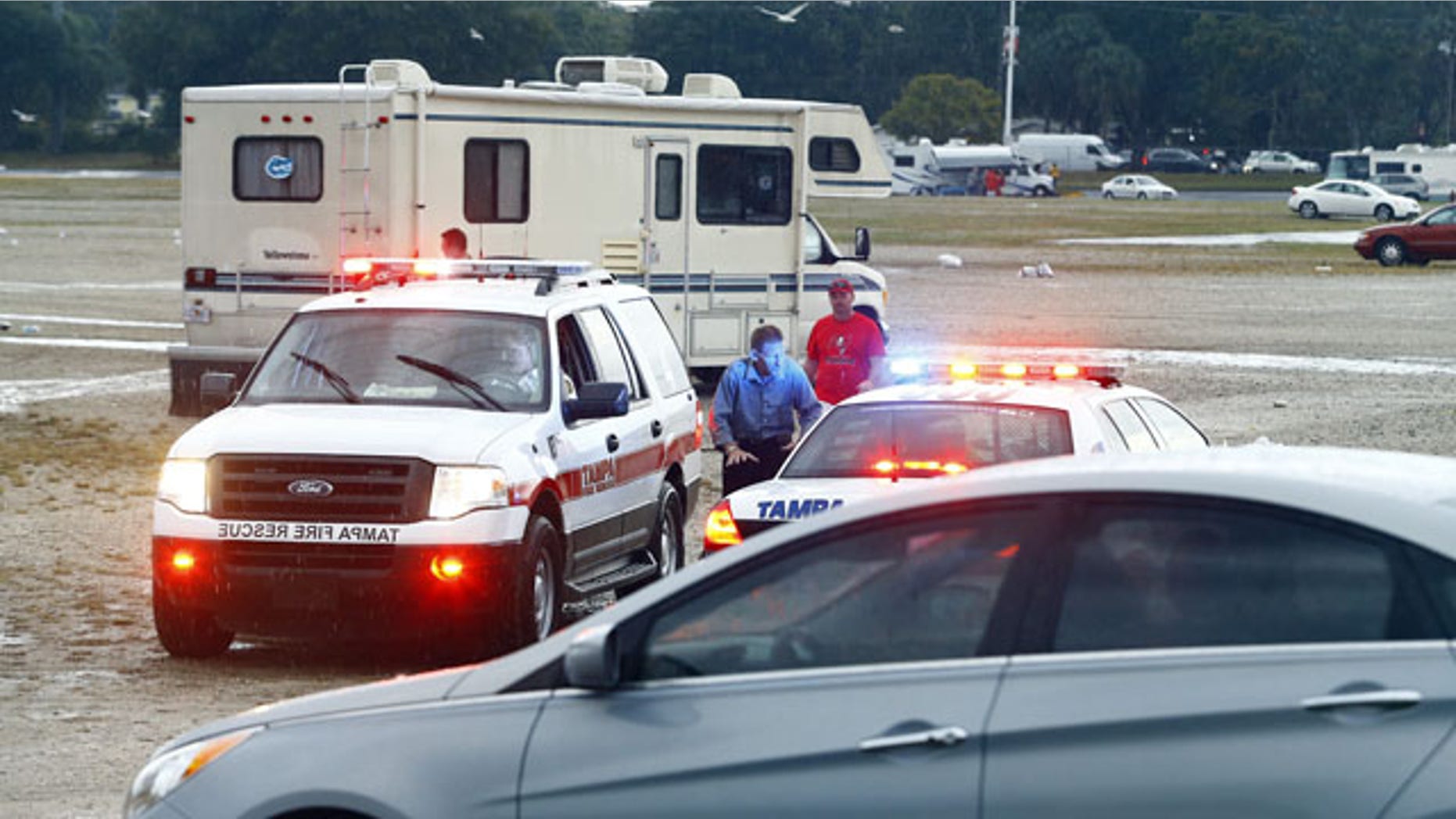 Dec. 21, 2014: Tampa Police Officers talk to spectators after football fans were reportedly taken to the hospital with injuries after a lightning strike near Raymond James Stadium. (AP Photo/Brian Blanco)