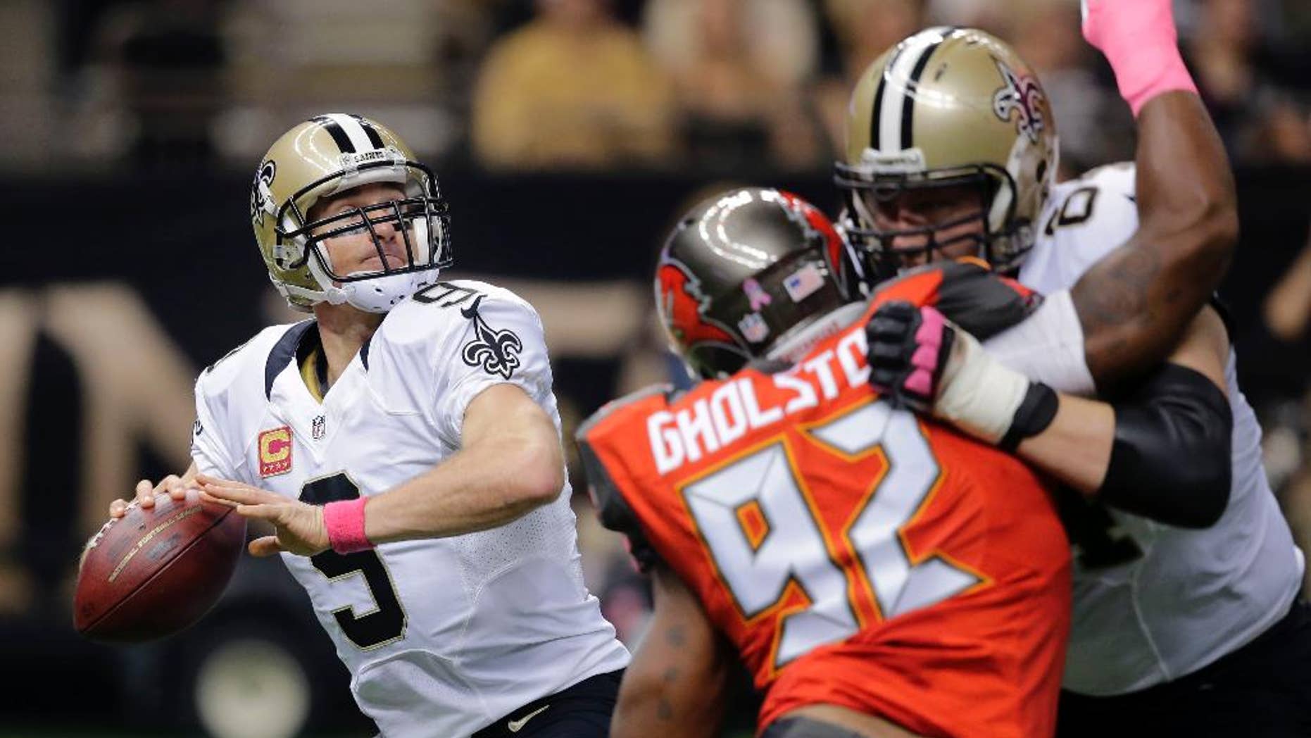 New Orleans Saints quarterback Drew Brees (9) drops back to pass under pressure from Tampa Bay Buccaneers defensive end William Gholston (92) in the first half of an NFL football game in New Orleans, Sunday, Oct. 5, 2014. (AP Photo/Bill Haber)