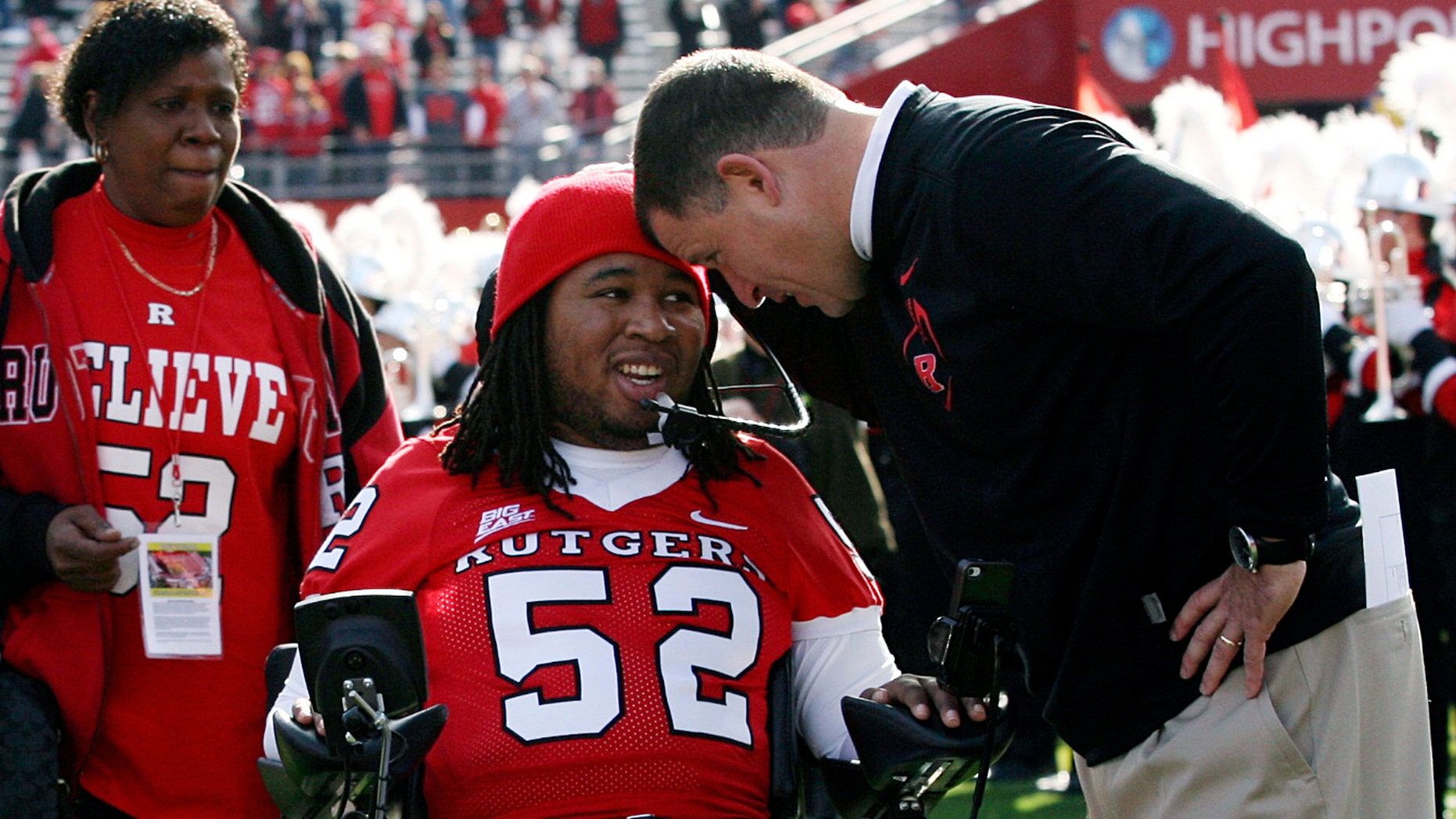 Nov. 19, 2011: In this file photo, paralyzed former Rutgers football player Eric LeGrand, center, is greeted by coach Greg Schiano, right, before an NCAA college football game against Cincinnati in Piscataway, N.J.