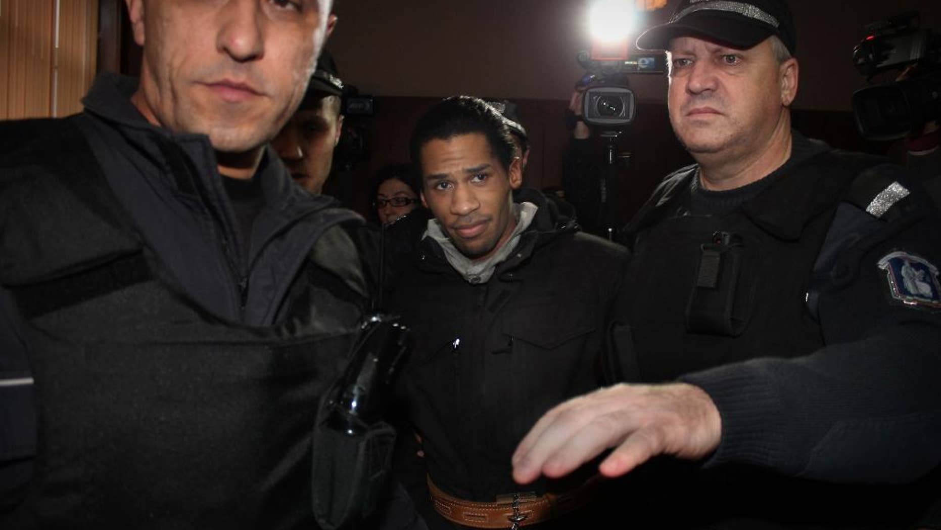 FILE - In this Tuesday, Jan. 20, 2015 file photo, police officers escort French citizen Fritz-Joly Joachin, center, inside a courtroom before a hearing in the town of Haskovo, Bulgaria. A Frenchman wanted in connection with deadly terrorist attacks in Paris was extradited on Thursday, Jan. 29, 2015 from Bulgaria to France, where he is facing charges of links to terrorism. (AP Photo-File)
