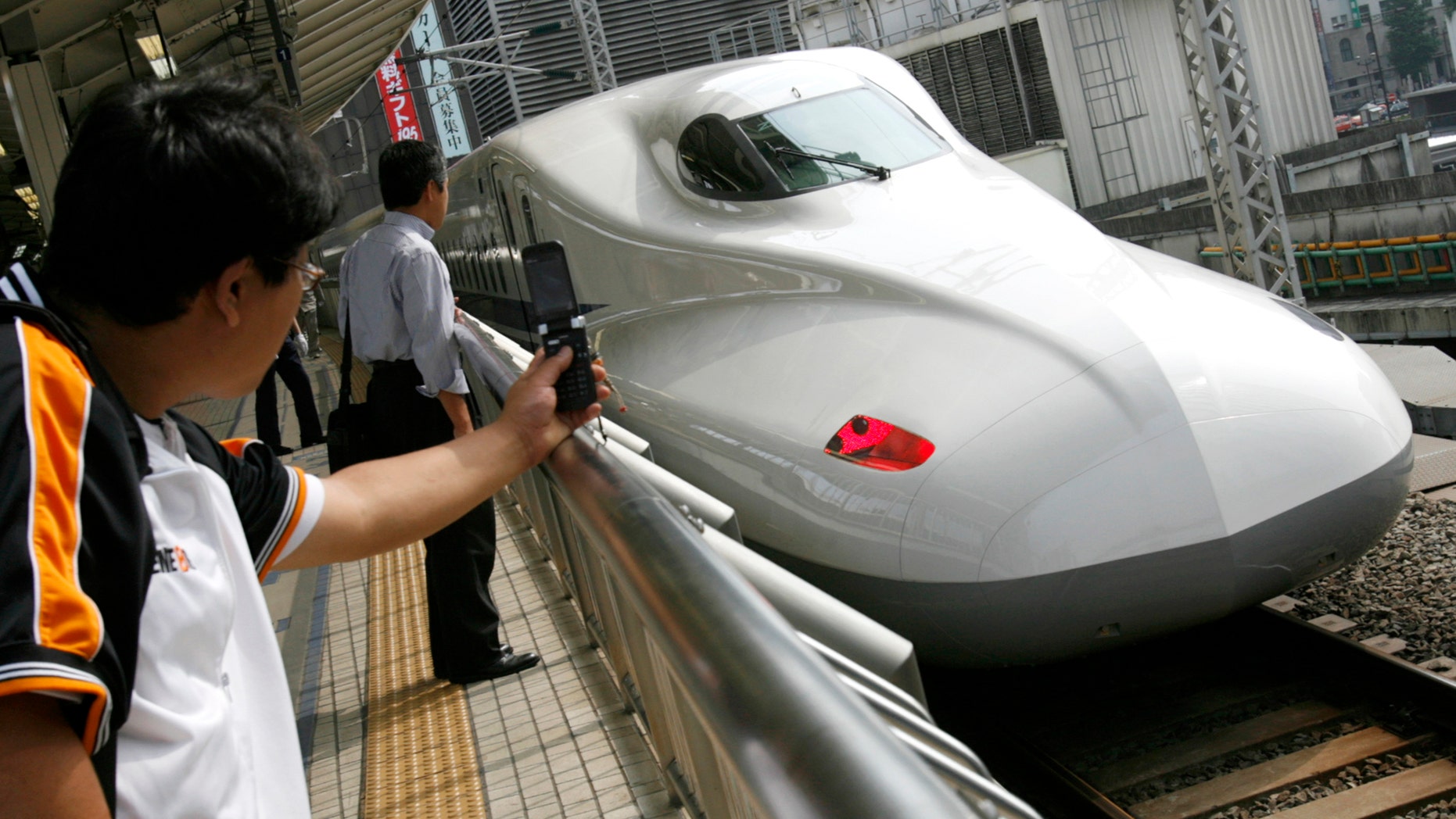 File photo - Men look at Japan Railway's N700 bullet train standing at a platform of Tokyo Station in Tokyo July 6, 2007.
