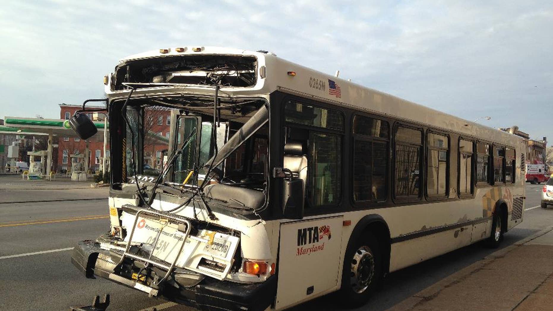 A tow truck prepares to remove a Maryland Transit Administration bus on Wednesday, Jan. 21, 2015, in Baltimore from the scene of its collision with a smaller transit administration bus for disabled riders. Passengers on the larger bus were injured; the disability service bus carried only the driver. (AP Photo/Juliet Linderman)