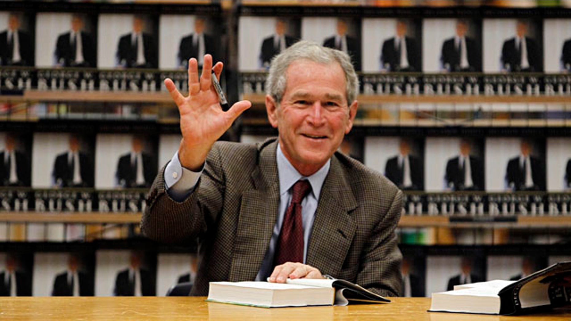 Nov. 9: Former President George W. Bush waves as he signs copies of his book, "Decision Points," at a store near his Dallas home. In the book, Bush lists several mistakes from his years in office--referring to the condition of the economy when he exited as "one ugly way to end a presidency."