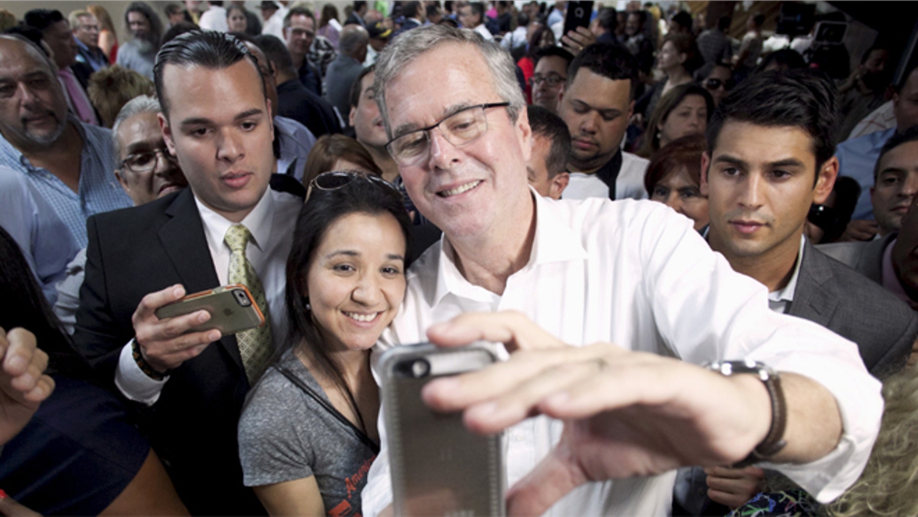FILE: April 28, 2015: Probable 2016 GOP presidential candidate and former Florida Gov. Jeb Bush (white shirt) poses for a selfie during a town hall meeting in San Juan, Puerto, Rico.