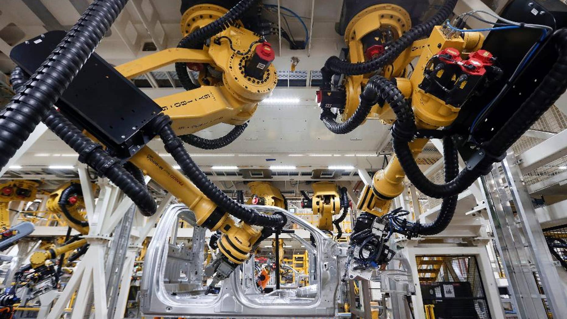 In this Nov. 11, 2014 photo, robots install rivets on a 2015 Ford F-150 truck at the Dearborn Truck Plant in Dearborn, Mich., Tuesday, Nov. 11, 2014. The Commerce Department releases business inventories for September on Friday, Nov. 14, 2014. (AP Photo/Paul Sancya)