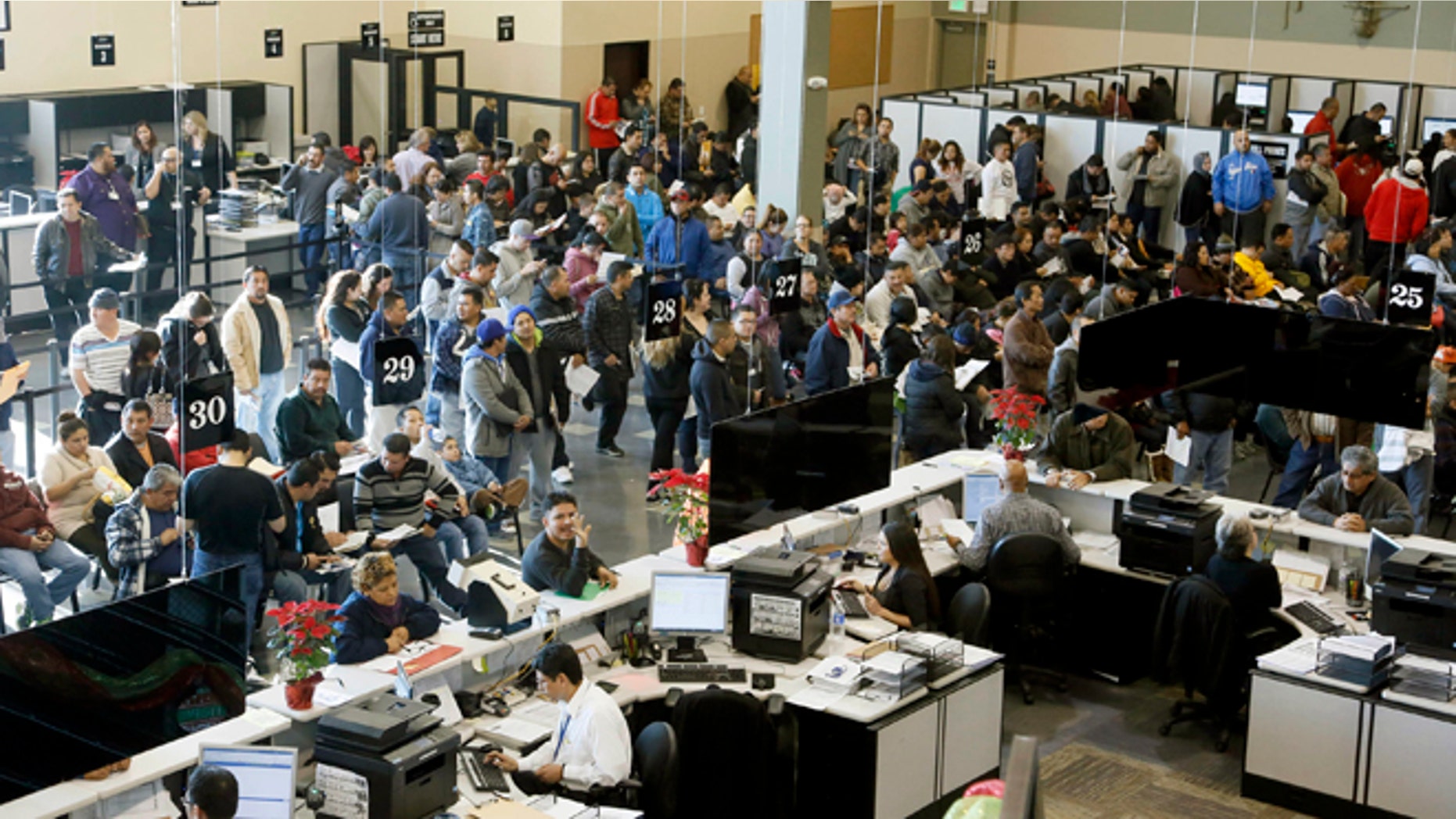 Immigrants line up at a California Department of Motor Vehicles office to register for drivers licenses in Stanton, Calif., Friday, Jan. 2, 2015. Hundreds of people packed into state offices and waited on hours-long lines Friday as California began issuing drivers licenses to the nations largest population of immigrants in the country illegally. Braving near-freezing temperatures, immigrants donning scarves and gloves and poring over drivers handbooks arrived at the newly-created Department of Motor Vehicles office in Stanton as early as 2 a.m. hoping to be among the first to obtain the long-sought driving permits. (AP Photo/Nick Ut)