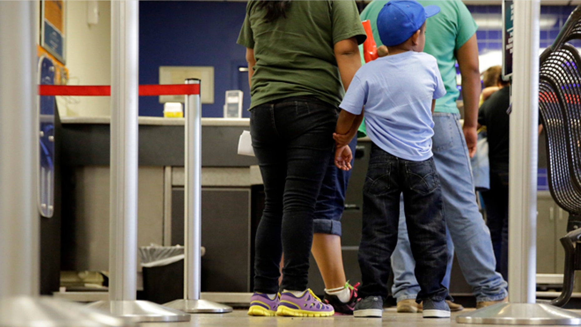 Immigrants from El Salvador who entered the country illegally stand in line at a bus on July 7, 2015.