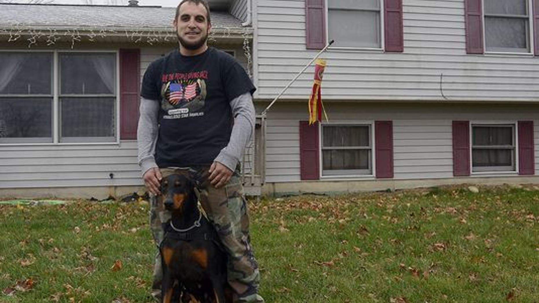 Eric Calley stands outside his Williamston house, December 17, 2014, with his service dog, Sun. Sun is trained to help him deal with PTSD from his service with the Marines in Iraq. (Photo: Dave Wasinger/Lansing State Journal)