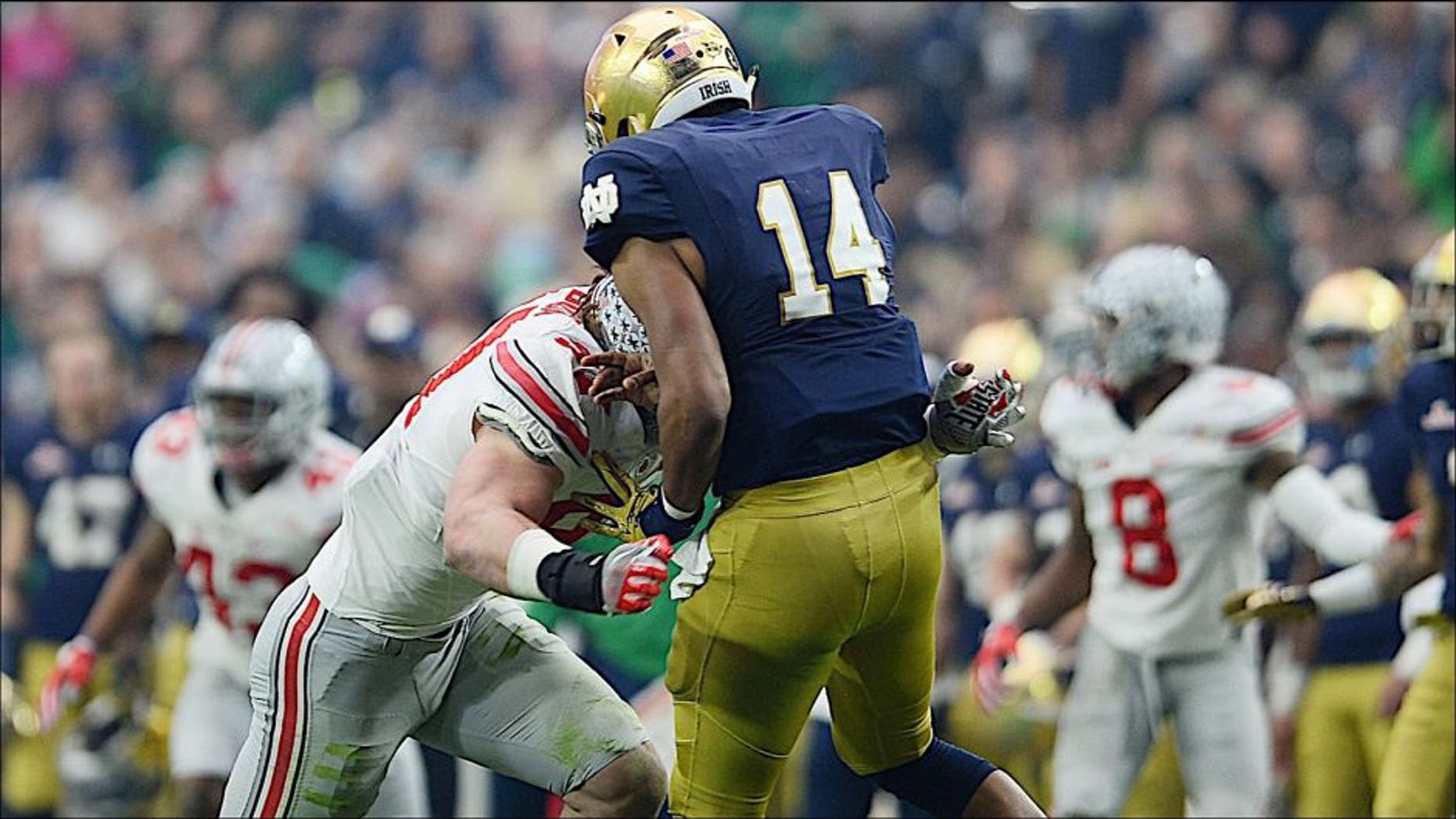 Jan 1, 2016; Glendale, AZ, USA; Ohio State Buckeyes defensive lineman Joey Bosa (97) hits Notre Dame Fighting Irish quarterback DeShone Kizer (14) during the first half of the 2016 Fiesta Bowl at University of Phoenix Stadium. Bosa would be penalized for targeting and ejected from the game. Mandatory Credit: Joe Camporeale-USA TODAY Sports