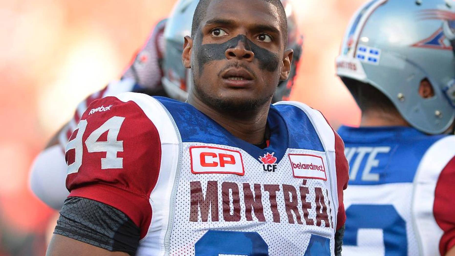 FILE - In this Aug. 7, 2014, file photo, Montreal Alouettes' Michael Sam and teammates warm up for a Canadian Football League game against the Ottawa Redblacks in Ottawa, Ontario. Sam is stepping away from pro football. Sam, the first openly gay player drafted by the NFL, has told the Alouettes that he is leaving the team. He tweeted Friday, Aug. 14, that "The last 12 months have been very difficult for me, to the point where I became concerned with my mental health. Because of this I am going to step away from the game at this time." (Justin Tang/The Canadian Press via AP, File)