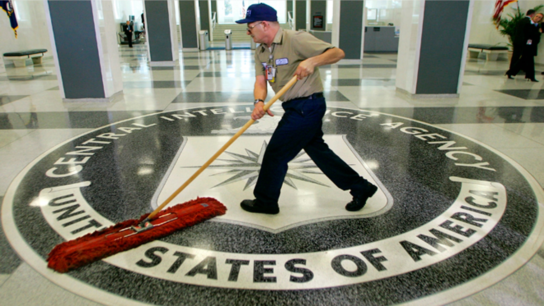 March 3, 2005: A workman quickly slides a dustmop over the floor at the Central Intelligence Agency headquarters in Langley, Va., near Washington.