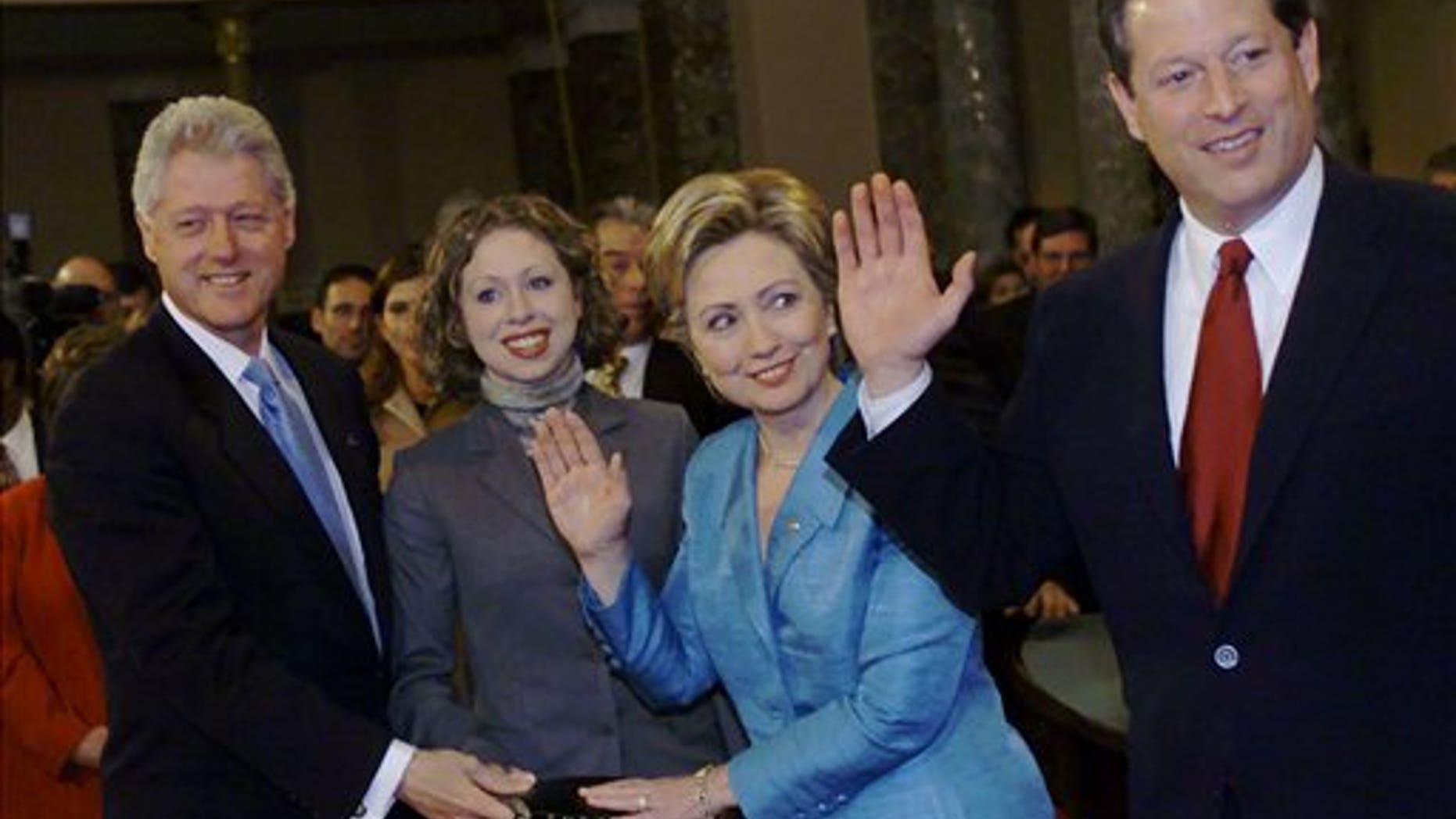 FILE - In this Jan. 3, 2001, file photo, then-President Bill Clinton, left, and daughter Chelsea hold a Bible during a mock swearing-in for freshman Sen. Hillary Rodham Clinton, D-N.Y. by Vice President Al Gore in Washington. (AP Photo/Hillery Smith Garrison, File)