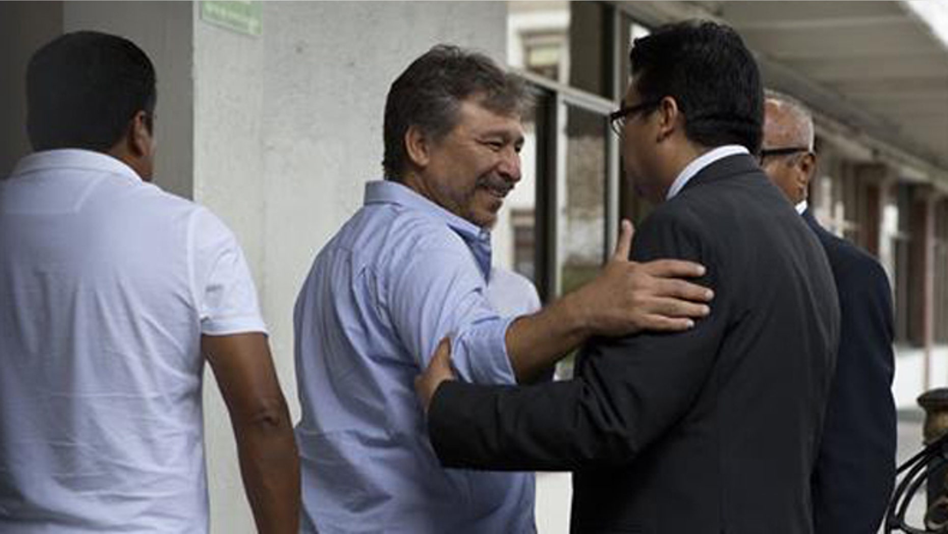 A member of a negotiation group comprised of protesting teachers and a mediation commission greets a government worker as he enters the Interior Ministry for a meeting with Secretary of the Interior Miguel Angel Osorio Chong, in Mexico City, Wednesday, June 22, 2016. The negotiations between the striking radical teachers and the government come three days after a clash between protestors and police in Oaxaca state left eight dead. Though who started shooting is disputed, journalists filmed police firing their weapons in the confrontation, which also left more than 100 injured. (AP Photo/Rebecca Blackwell)