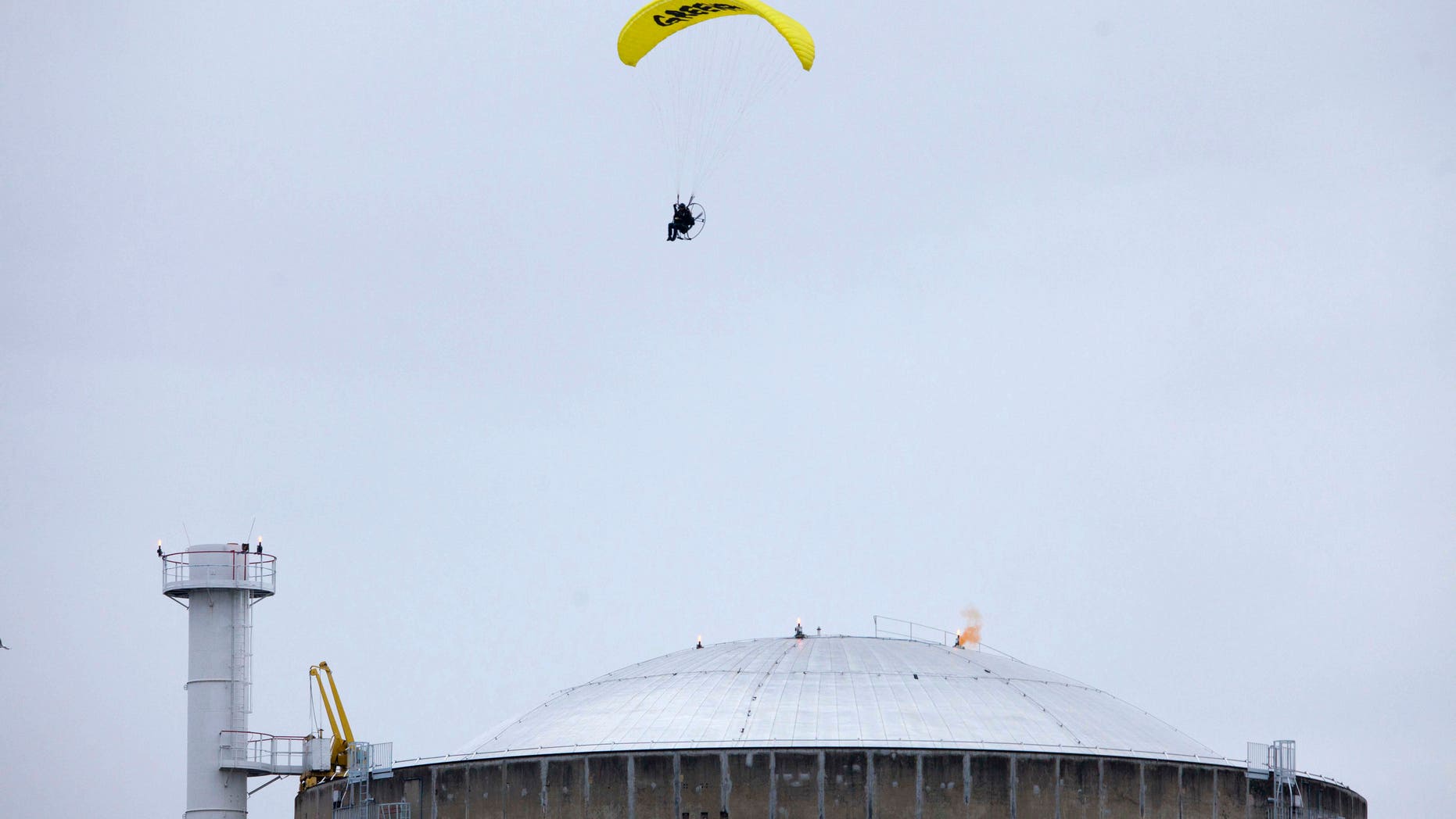 May 2, 2012: In this photo provided by Greenpeace, an activist in a motorized paraglider flies over the Bugey nuclear power plant, near Saint-Vulbas, central France, and drops a flare on the roof.