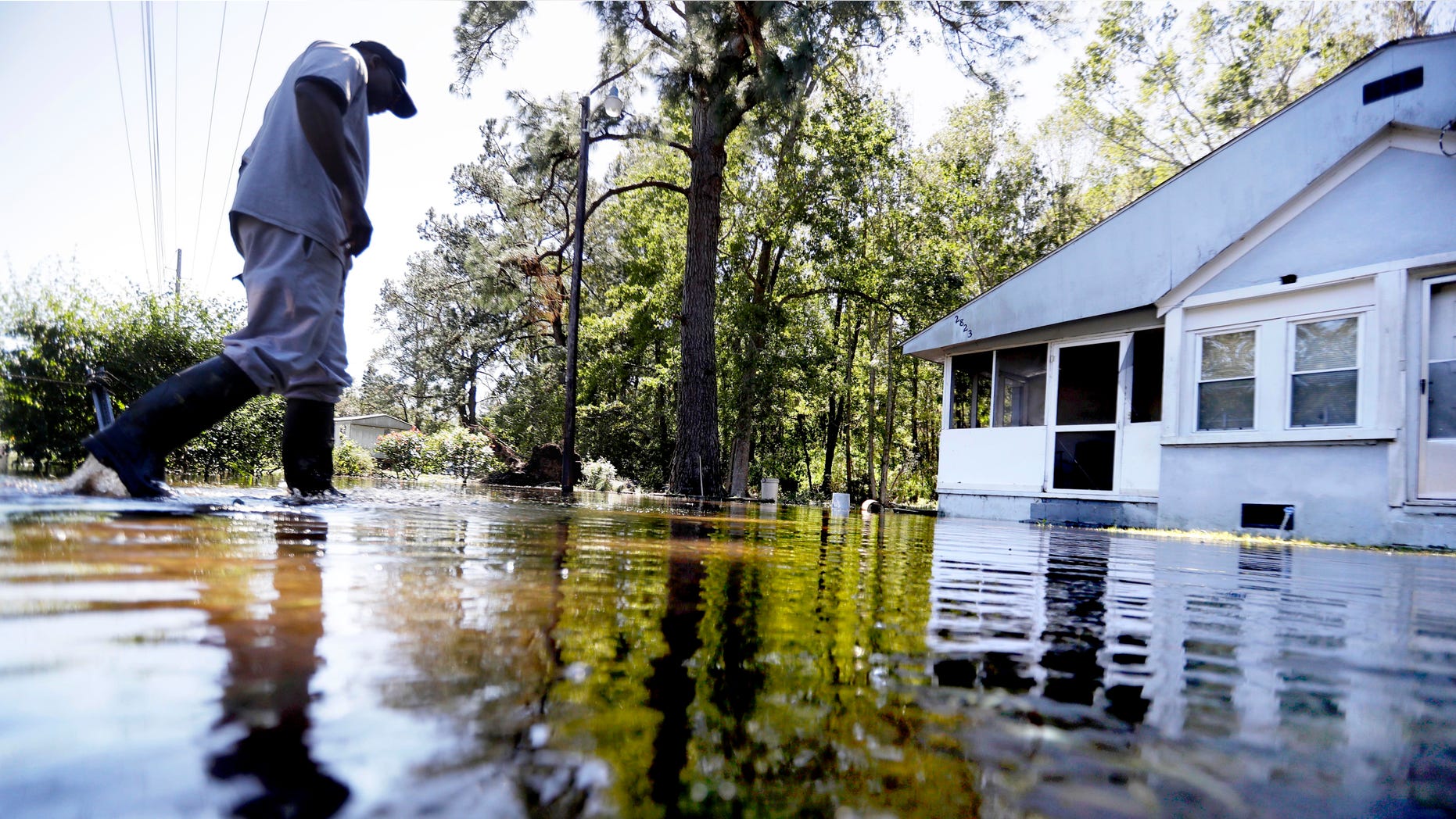 CORRECTS TO EDISTO ISLAND SOUTH CAROLINA, NOT GEORGIA - Kyle Simmons wades through water to check on the home of his grandmother following Hurricane Matthew in Edisto Island, S.C., Sunday, Oct. 9, 2016. A deteriorating Matthew was stripped of hurricane status Sunday morning and began making its slow exit to the sea. (AP Photo/David Goldman)