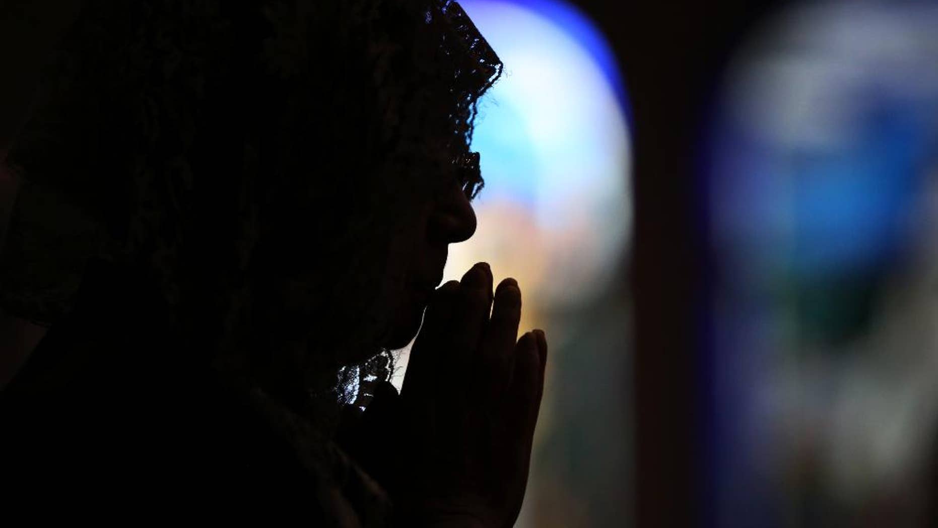 CORRECTS THE NUMBER OF THE VICTIMS- A Catholic offers prayers at an early morning mass to pay respect to the victims of the Nagasaki atomic bombing at the Urakami Cathedral in Nagasaki, southern Japan Sunday, Aug. 9, 2015. Ceremony for the 70th anniversary of the atomic bombing will start late this morning. The atomic bomb attack on this city that left more than 70,000 dead and hastened the end of World War II exactly 70 years ago.(AP Photo/Eugene Hoshiko)