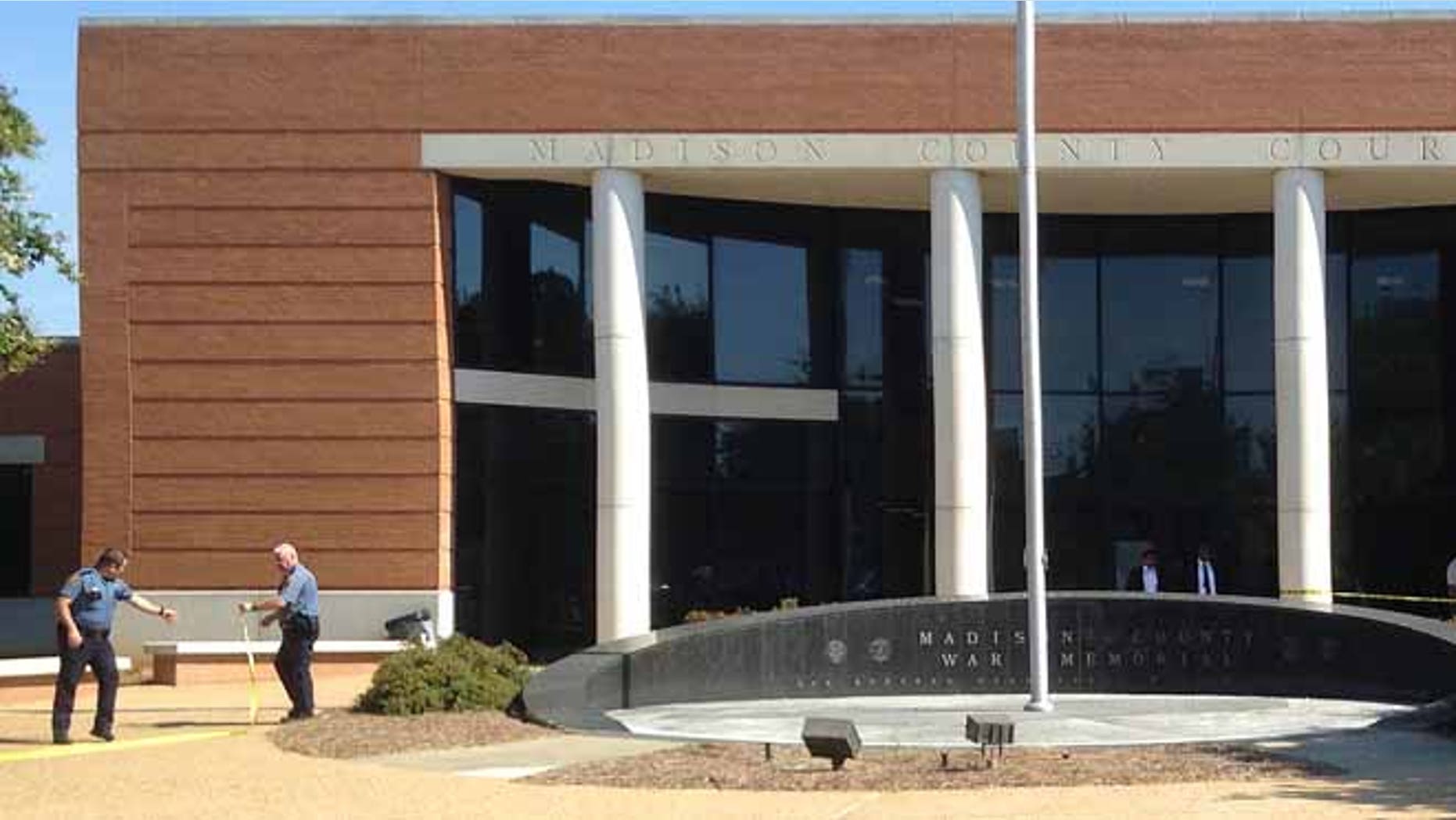 Authorities investigate near where a man fatally shot a defendant waiting in a small courtyard outside a criminal courthouse in Mississippi.