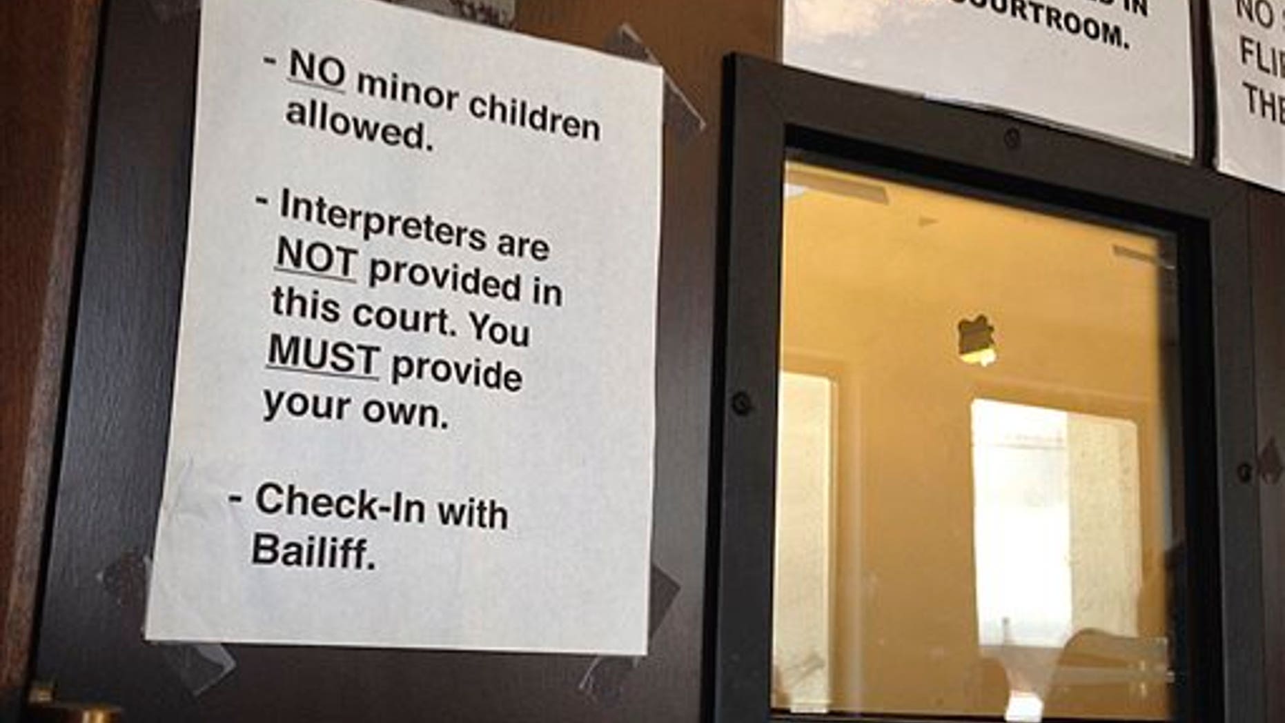 In this Wednesday, Aug. 5, 2015 photo, a sign stating no interpreters are provided is seen on the front door of the courtroom of Judge Don Franchi in San Mateo Superior Court in Redwood City, Calif. (AP Photo/Sudhin Thanawala)