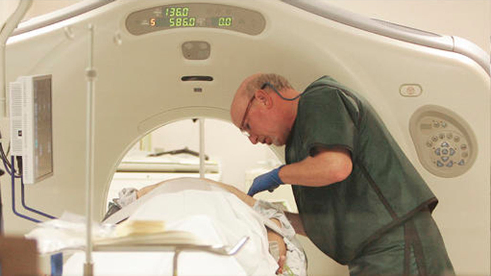 In this photo taken Thursday, June 3, 2010, Dr. Steven Birnbaum works a CT scanner with a patient at Southern New Hampshire Medical Center in Nashua, N.H. (AP Photo/Jim Cole)
