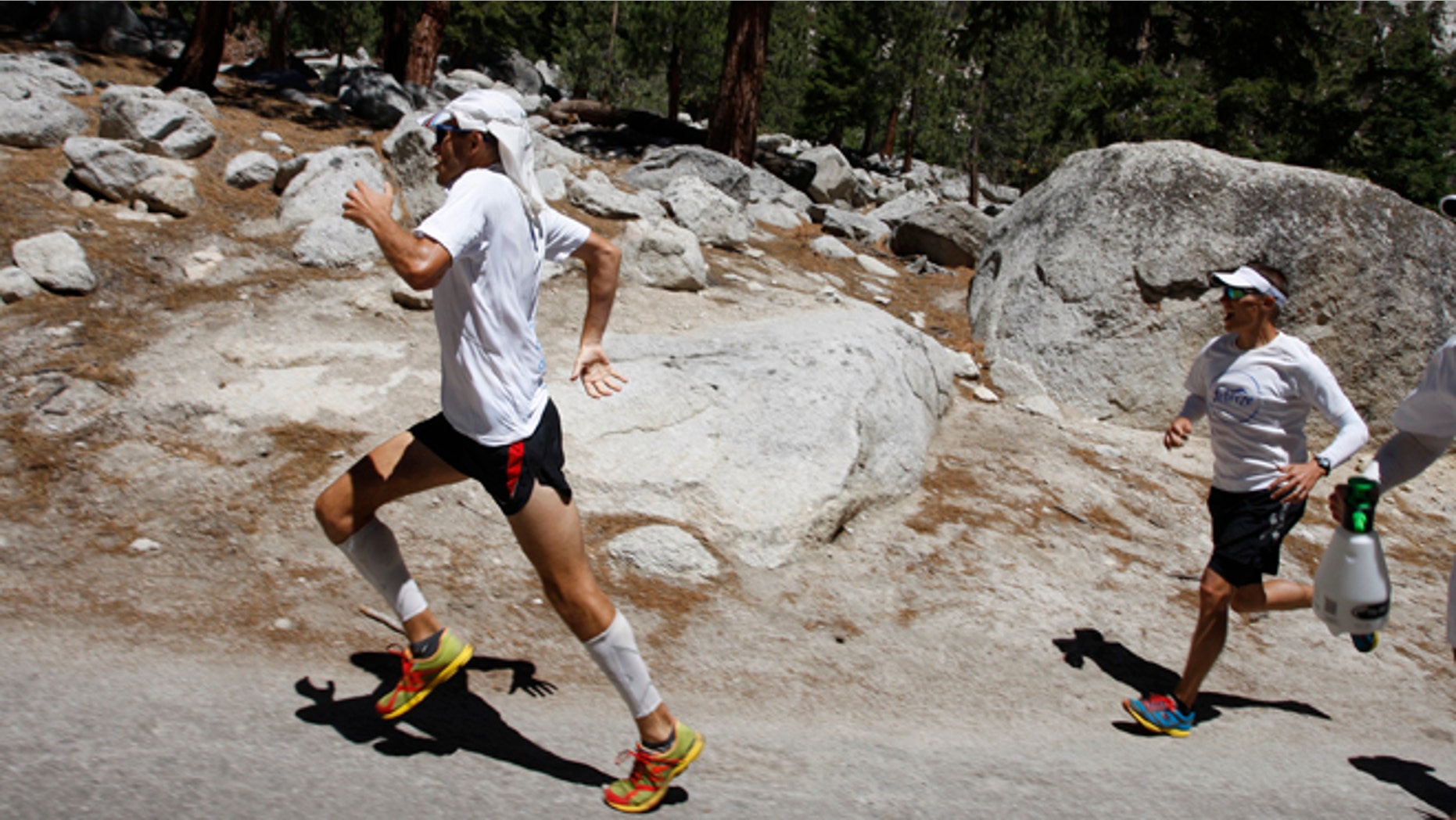 DEATH VALLEY NATIONAL PARK, CA - JULY 16: Harvey Sweetland Lewis III sprints hard, leaving his support crew behind, toward the finish to take fourth place in the AdventurCORPS Badwater 135 ultra-marathon race on July 16, 2013 outside of Death Valley National Park, California. Billed as the toughest footrace in the world, the 36th annual Badwater 135 starts at Badwater Basin in Death Valley, 280 feet below sea level, where athletes begin a 135-mile non-stop run over three mountain ranges in extreme mid-summer desert heat to finish at 8,350 feet above sea level near Mount Whitney for a total cumulative vertical ascent of 13,000 feet. July 10 marked the 100-year anniversary of the all-time hottest world record temperature of 134 degrees, set in Death Valley where the average high in July is 116. A total of 96 competitors from 22 nations attempted the run which equals about five back-to-back marathons. Previous winners have completed all 135 miles in less than 24 hours. (Photo by David McNew/Getty Images)