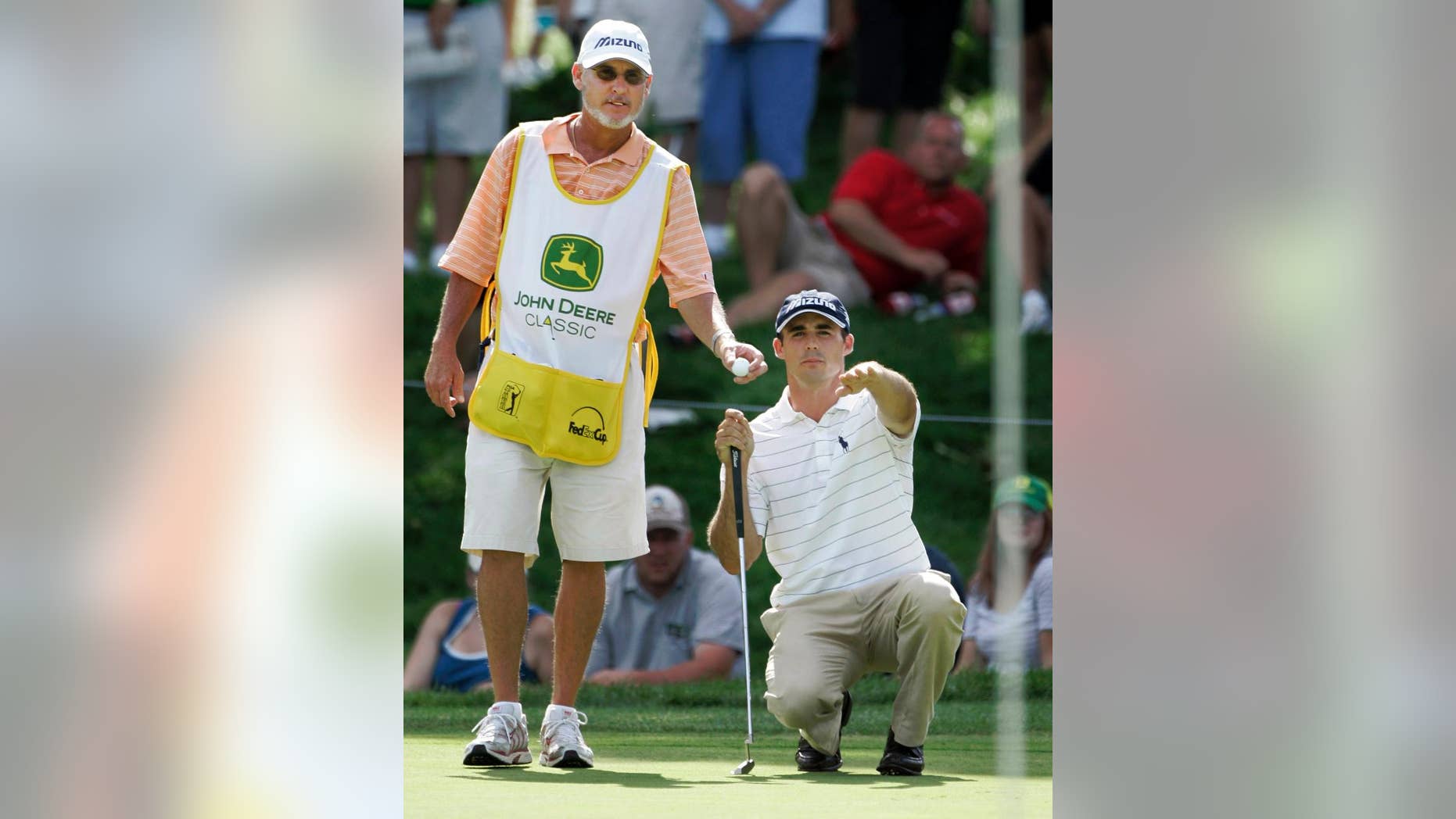 FILE - In this July 15, 2007, file photo, golfer Jonathan Byrd, right, shows caddie Mike Hicks the contour of the 17th green during John Deere Classic golf tournament at the TPC Deere Run golf course in Silvis, Ill. A group of PGA Tour caddies has filed a class-action lawsuit Tuesday, Feb. 3, 2015, in northern California, demanding that the tour compensate them for wearing bibs. Hicks was named as the two class representatives. The other was Kenny Harms, who caddies for Kevin Na. (AP Photo/Charles Rex Arbogast, File)