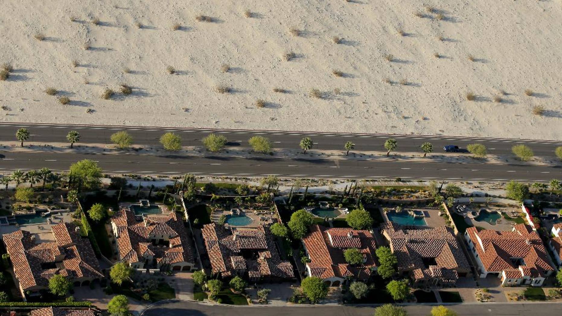 Homes with swimming pools border the desert of this neighborhood Friday, April 3, 2015, in Cathedral City, Calif. California Gov. Jerry Brown ordered officials Wednesday to impose statewide mandatory water restrictions for the first time in history as surveyors found the lowest snow level in the Sierra Nevada snowpack in 65 years of record-keeping. (AP Photo/Chris Carlson)