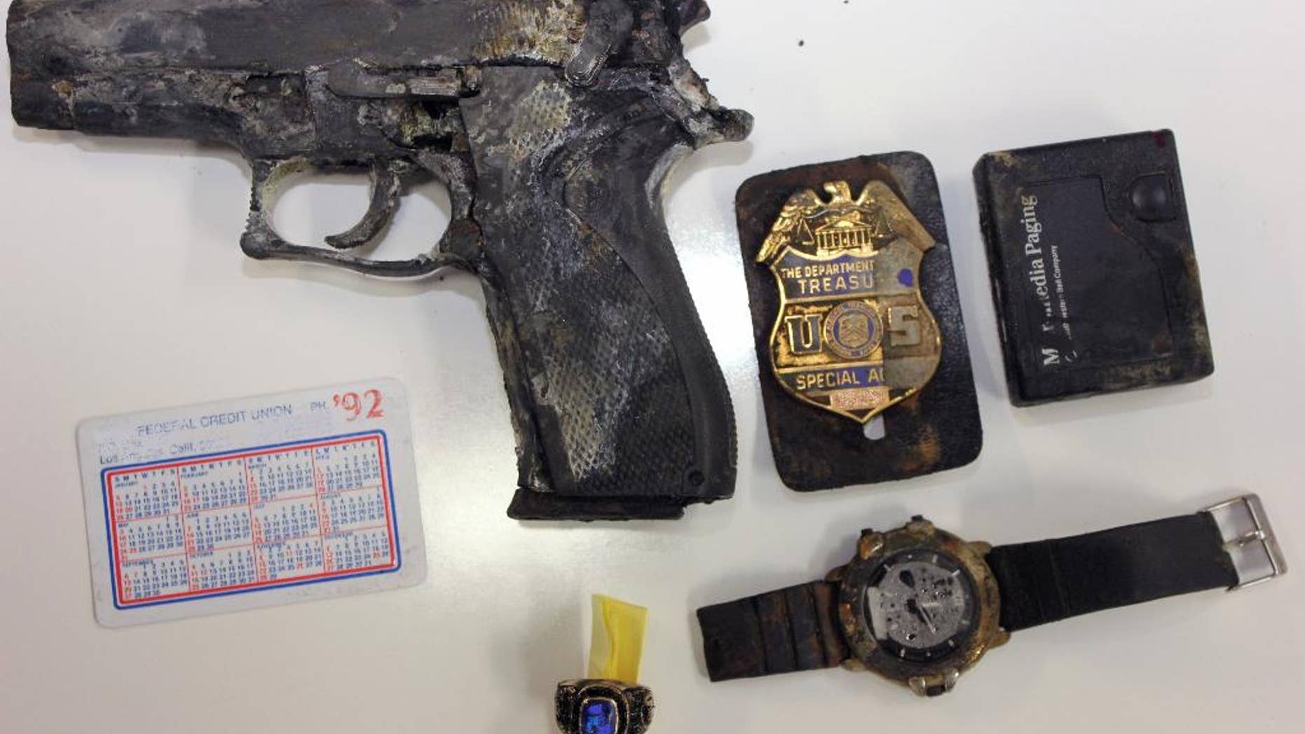 This undated photo provided by the Los Angeles County Sheriff’s Department shows several items, including a handgun and badge of a federal agent, found in a backpack in shallow water by a man fishing at Castaic Lake in northern Los Angeles County. The agent said he got grief from his co-workers after his backpack went overboard during a 1992 boat trip, according to the Los Angeles Times. (AP Photo/ Los Angeles County Sheriff’s Department)