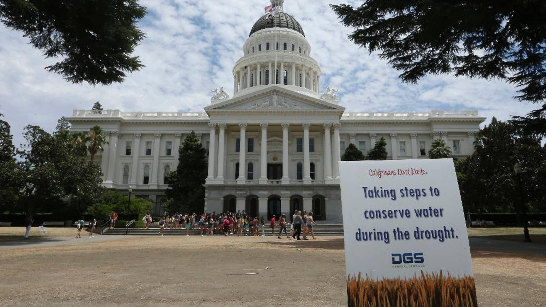 A sign alerts visitors to water conservation efforts at the state Capitol, Tuesday, July 8, 2014, in Sacramento, Calif. State water regulators are considering fines up to $500 for excessive water use for things like irrigating lawns and car washing due to the state's severe drought. (AP Photo/Rich Pedroncelli)