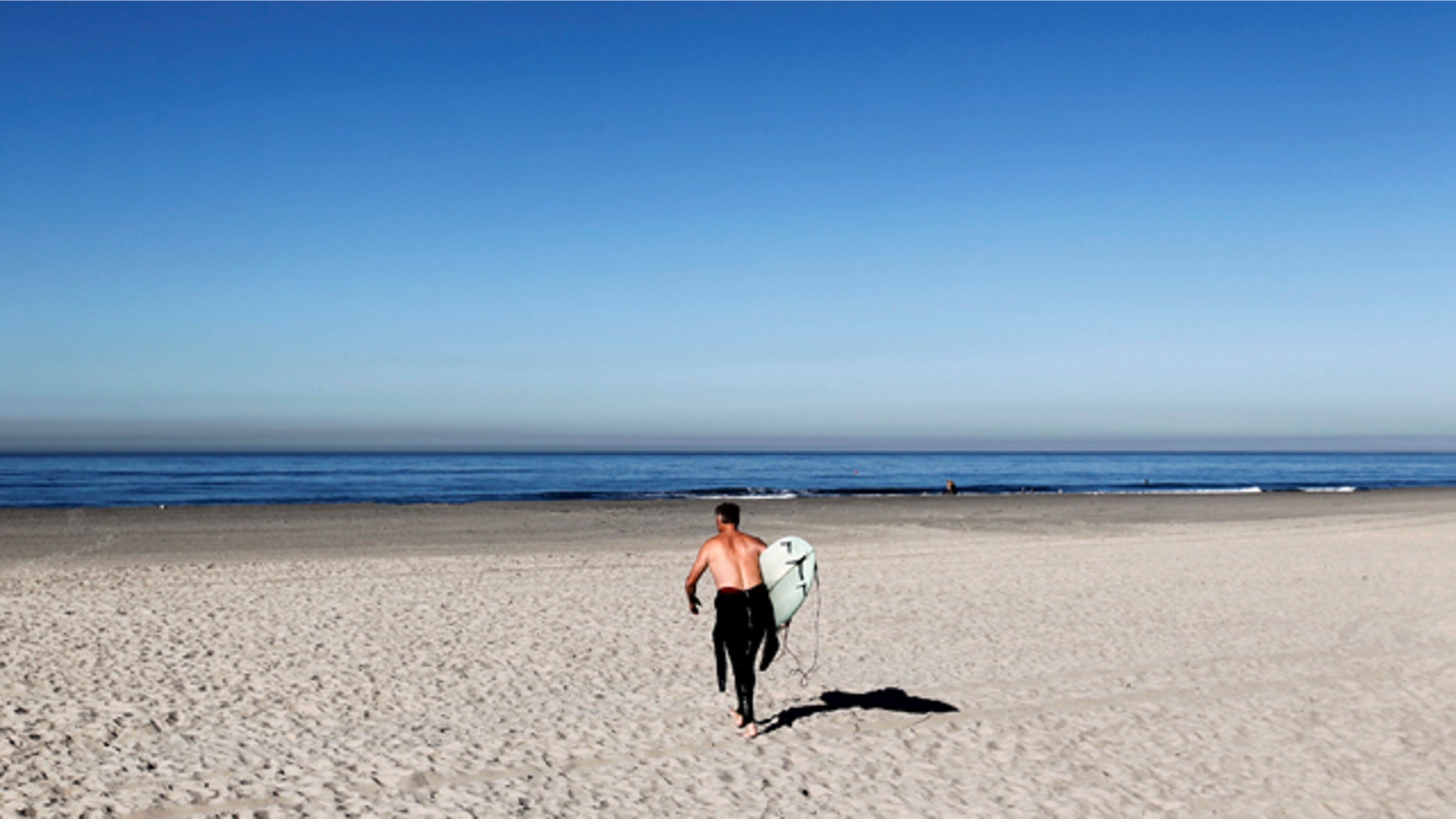 Dec. 13, 2010: A lone surfer walks out to ride waves at Pacific Beach during a warm weather spell in San Diego, Calif.